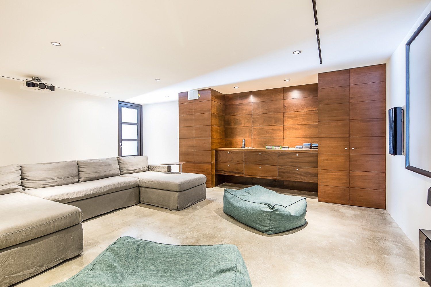 a living room with a large sectional couch and bean bag chairs .
