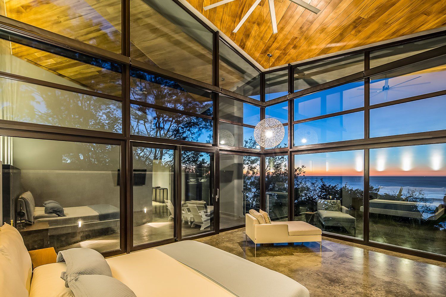 a bedroom with a lot of windows and a view of the ocean .