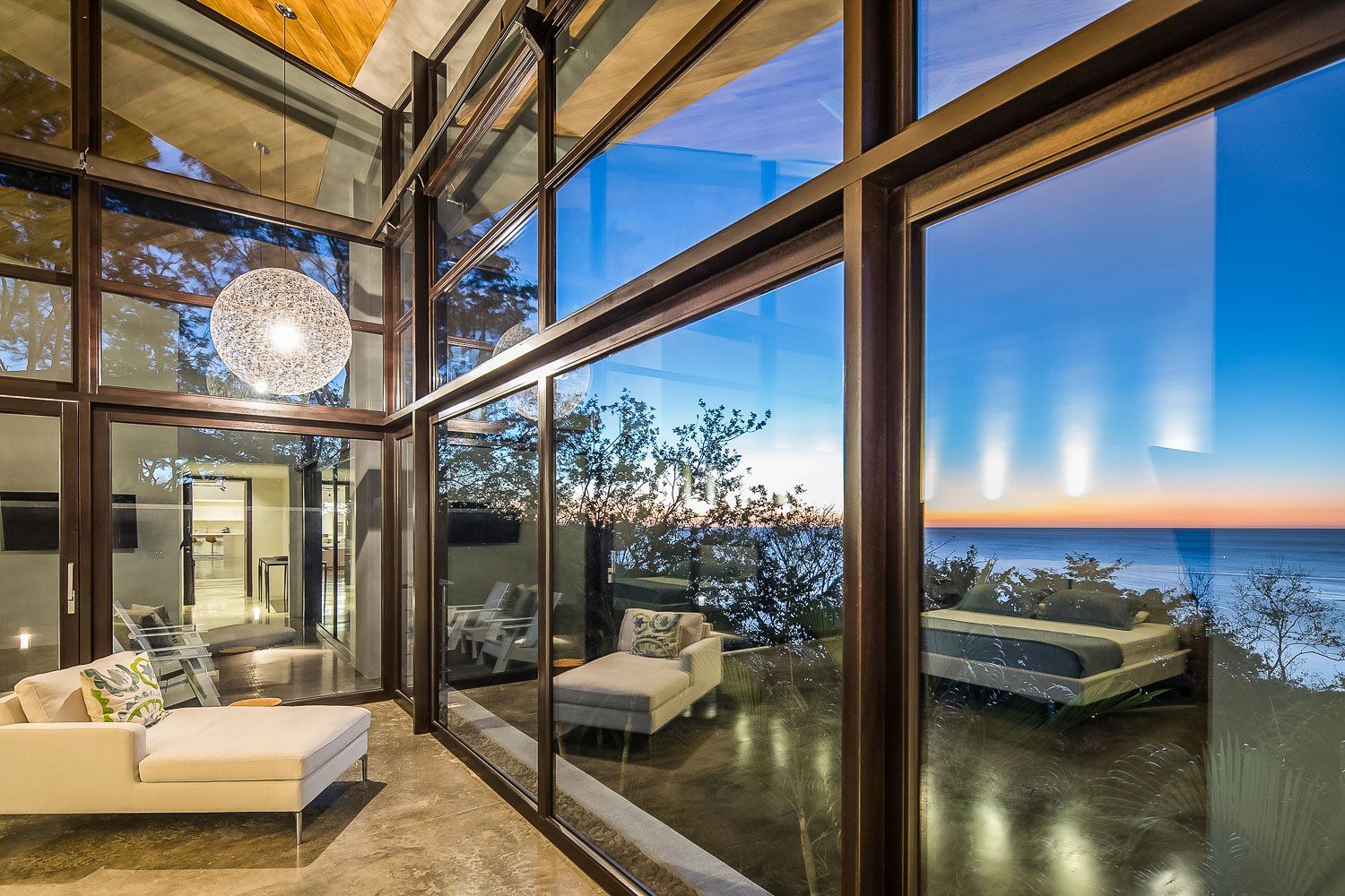 a living room with a lot of windows and a view of the ocean .