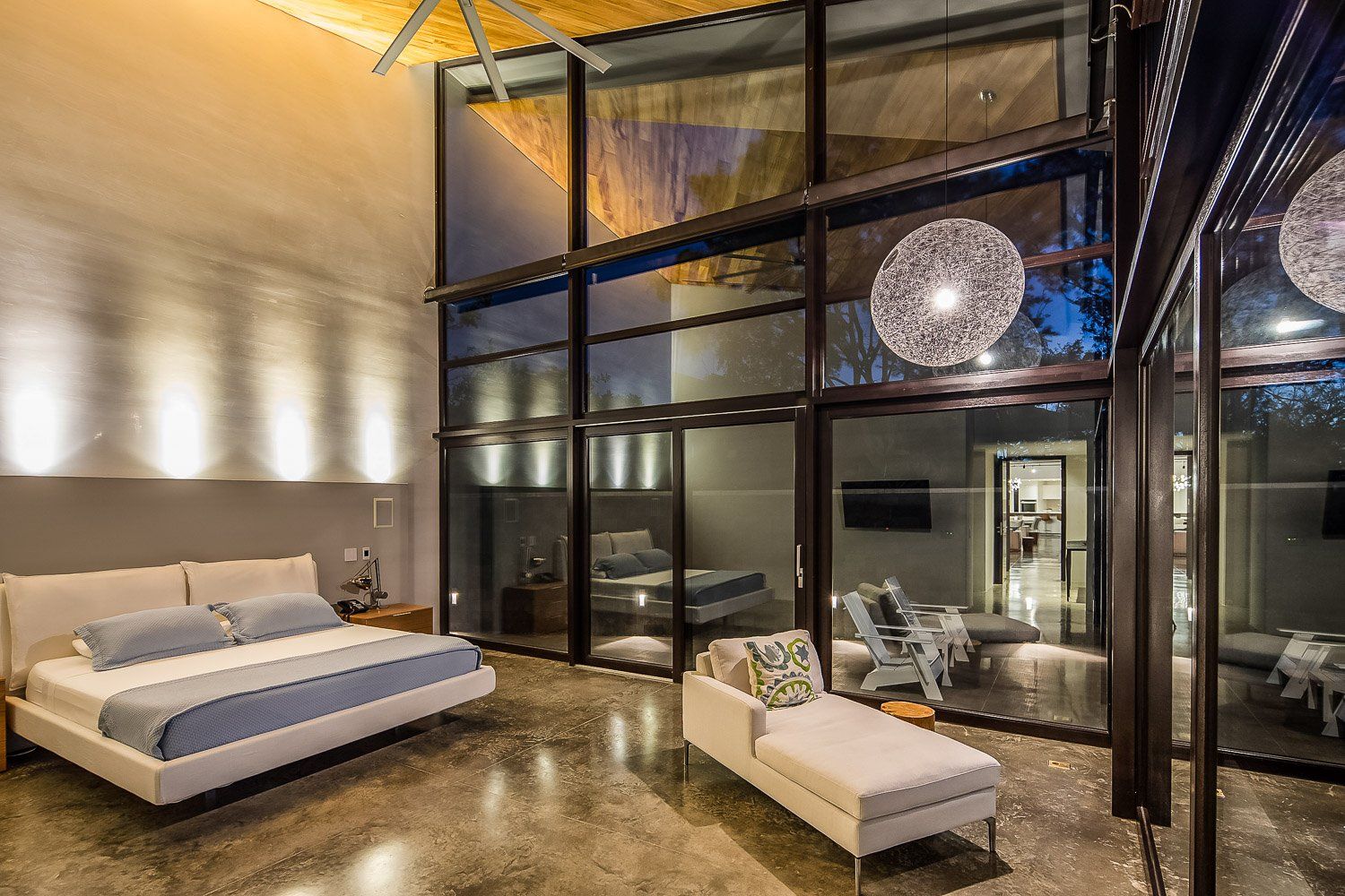 a bedroom with a large bed and lots of windows .