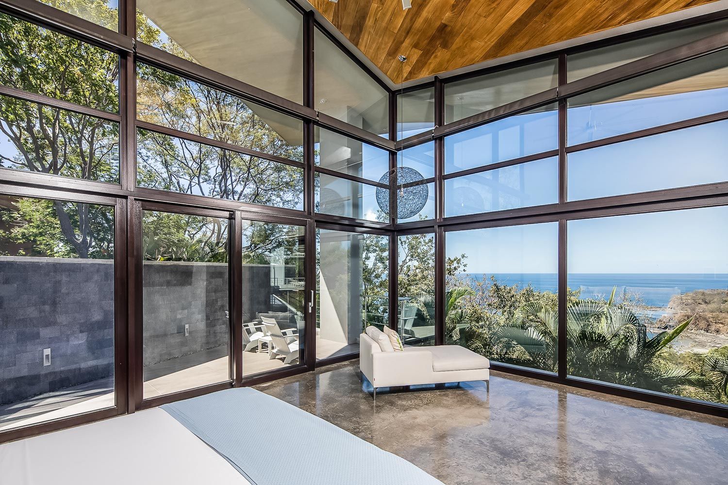 a bedroom with a lot of windows and a view of the ocean .