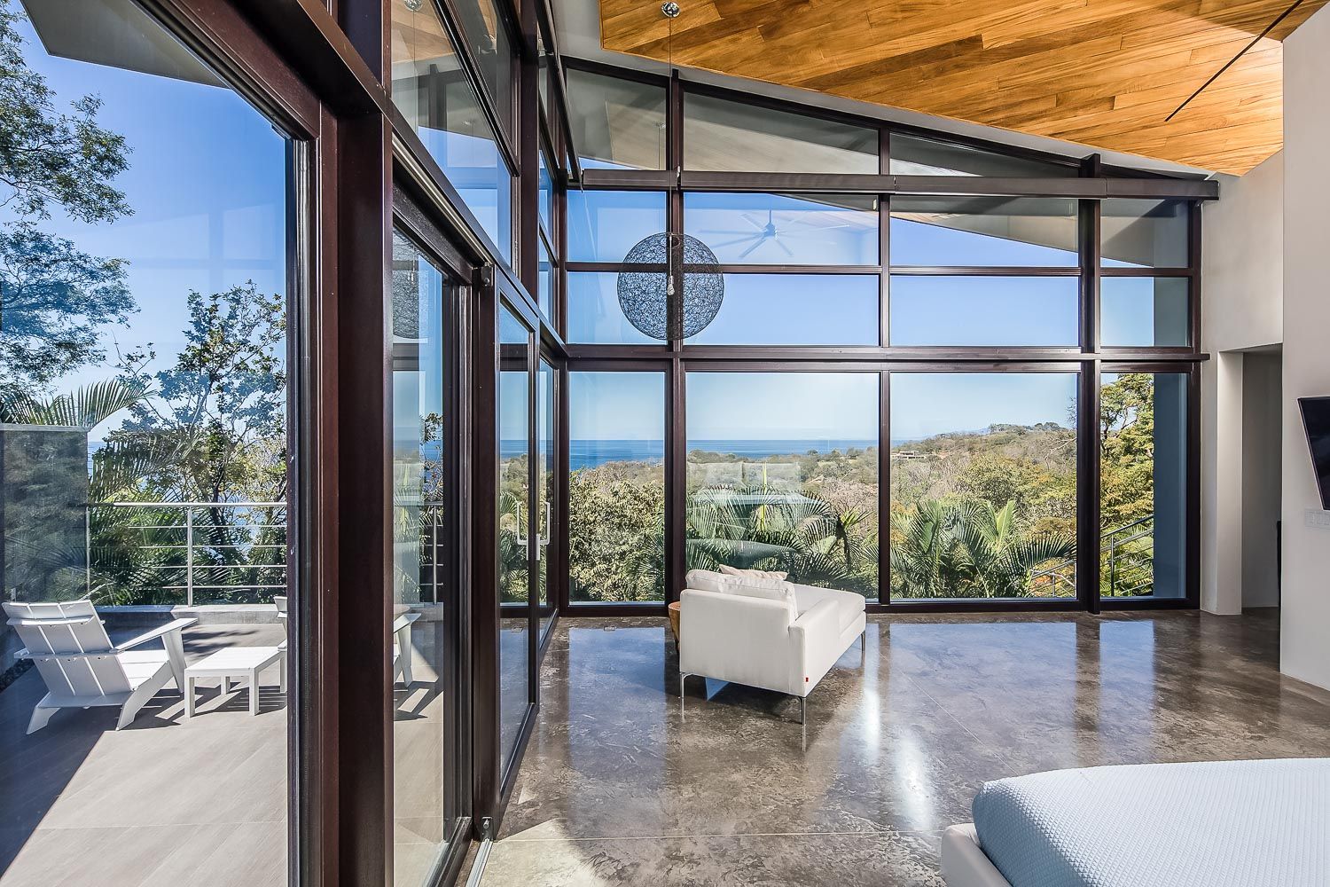 a bedroom with a lot of windows and a view of the ocean