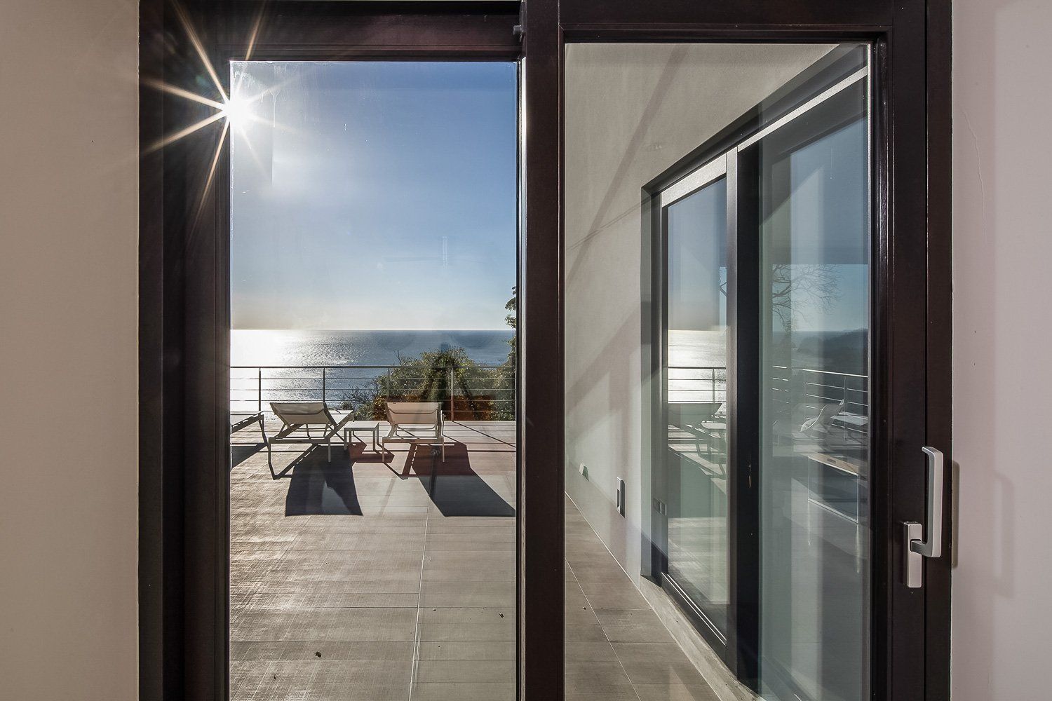 a sliding glass door leading to a balcony overlooking the ocean .