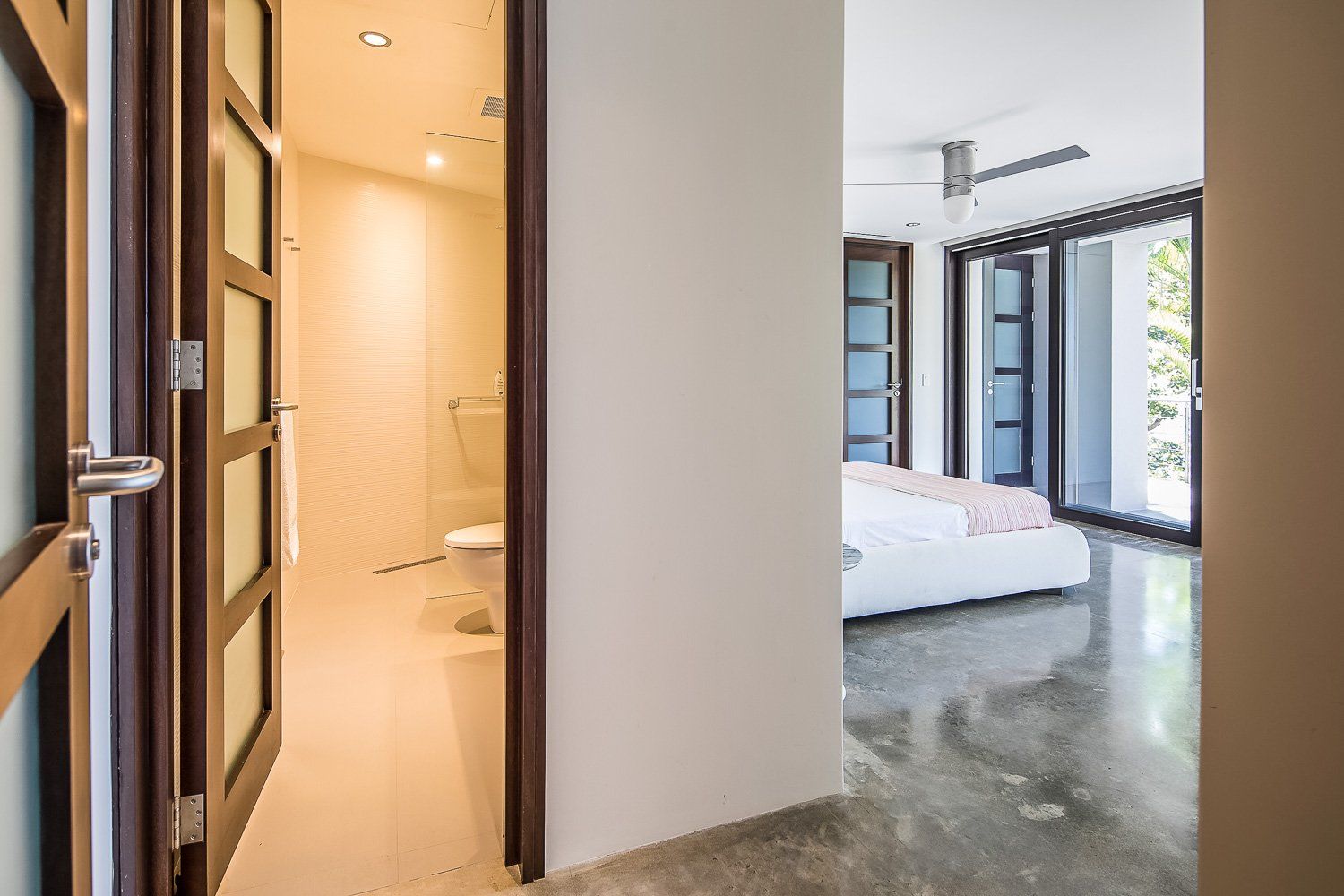 a hallway in a house leading to a bedroom and bathroom . Sarco