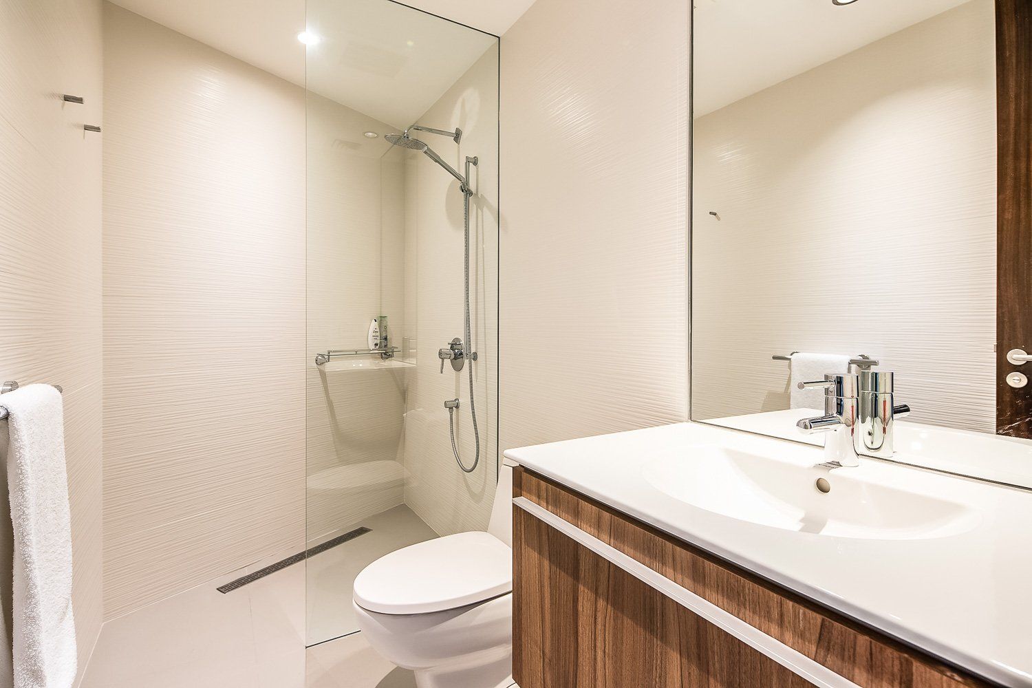 a bathroom with a toilet , sink and shower . Sarco