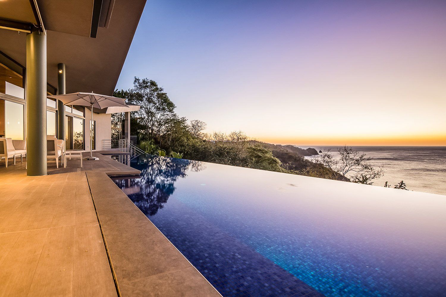 a large swimming pool with a view of the ocean. Sarco