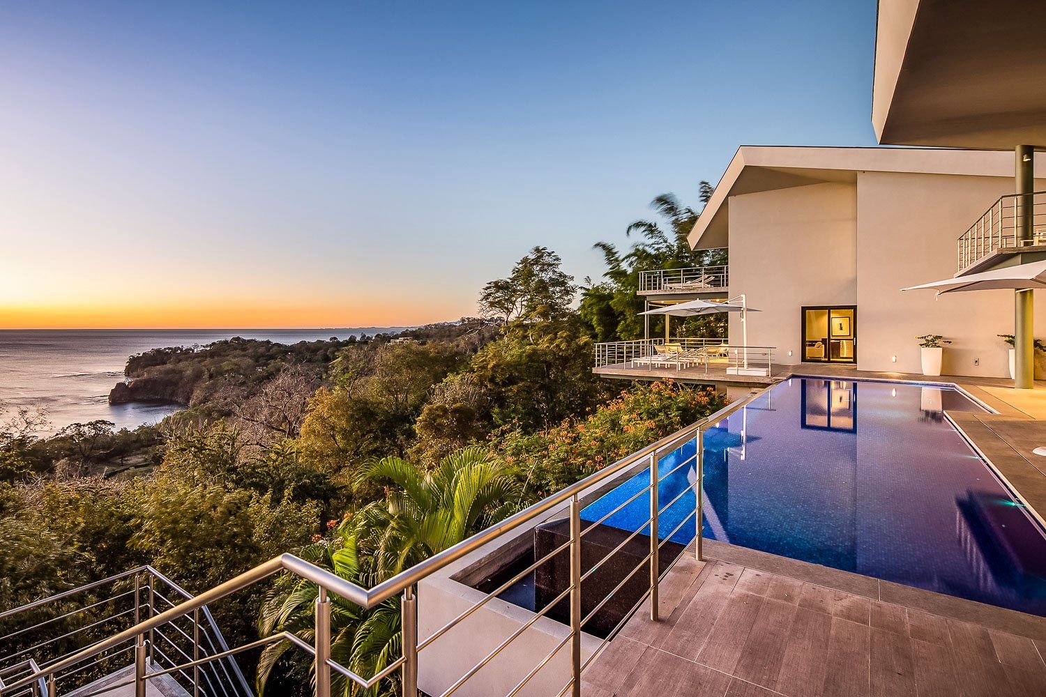 a large house with a swimming pool overlooking the ocean