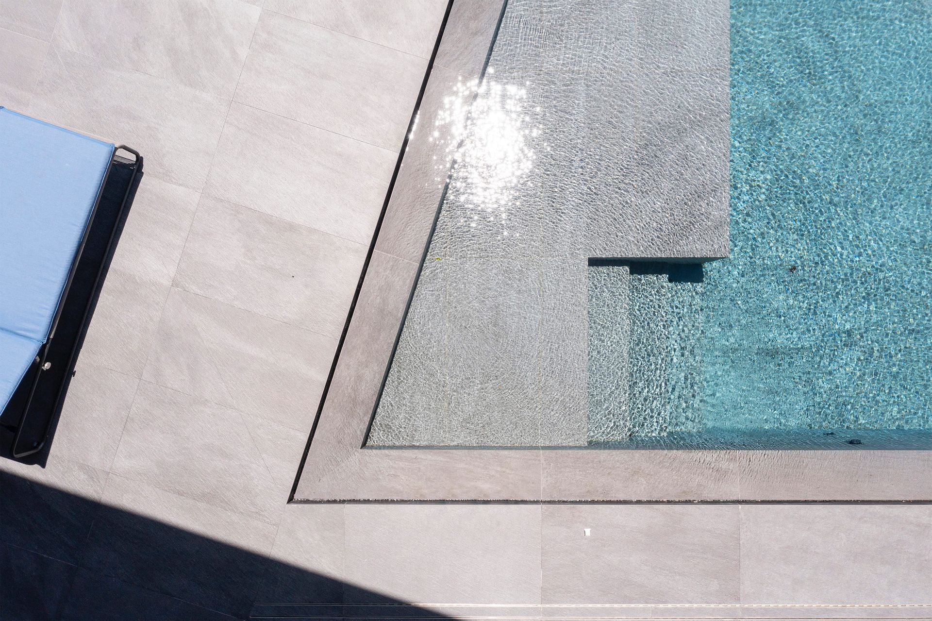 an aerial view of a swimming pool with a chair in the foreground .