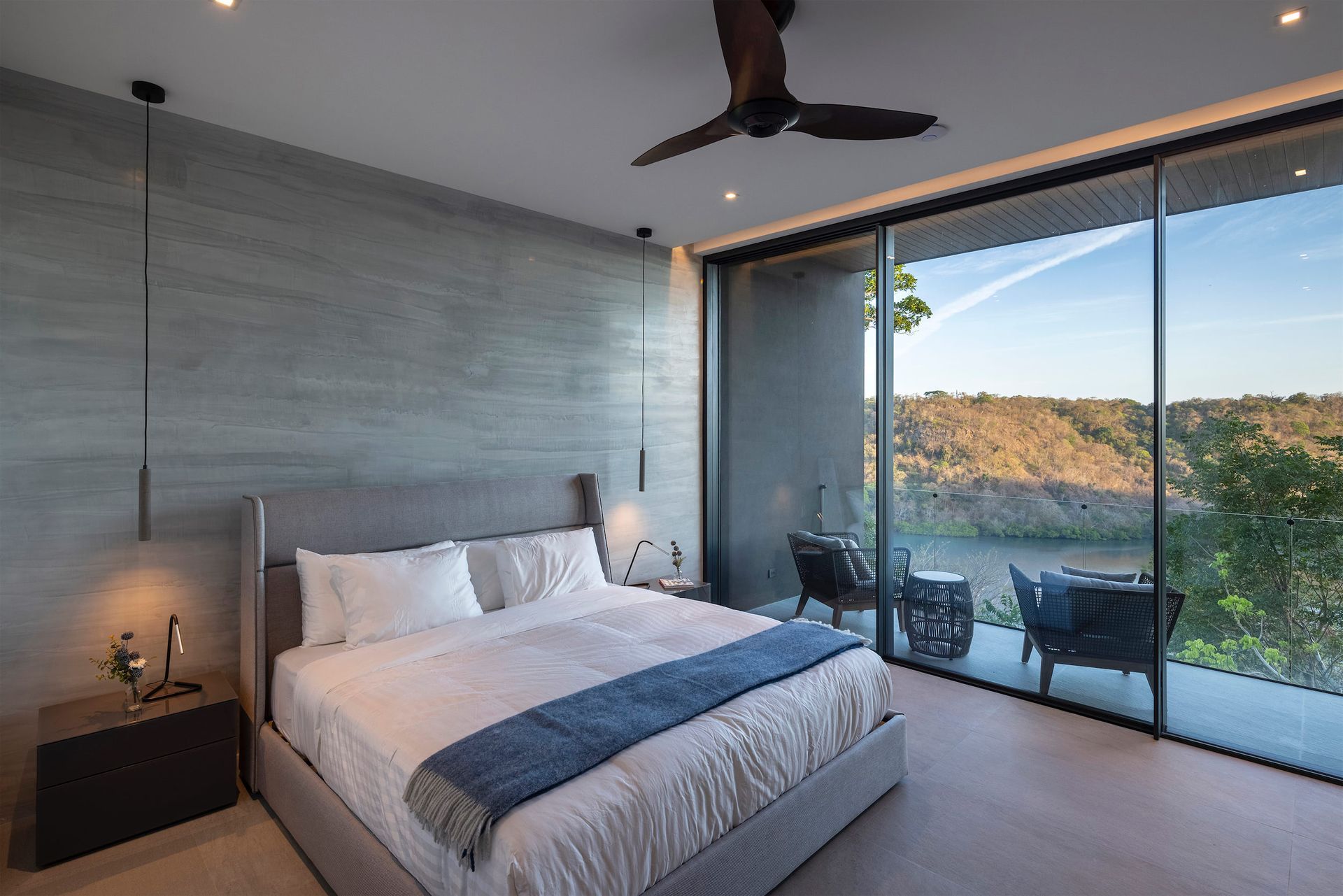 a bedroom with a large bed and a ceiling fan .