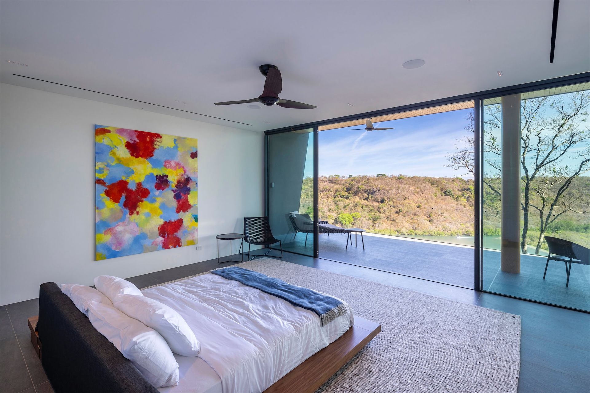 a bedroom with a large bed and a painting on the wall .