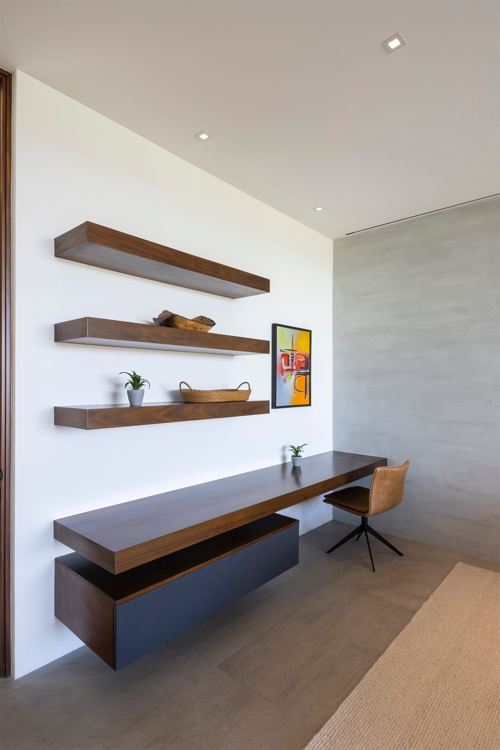 there is a desk and a chair in the room .