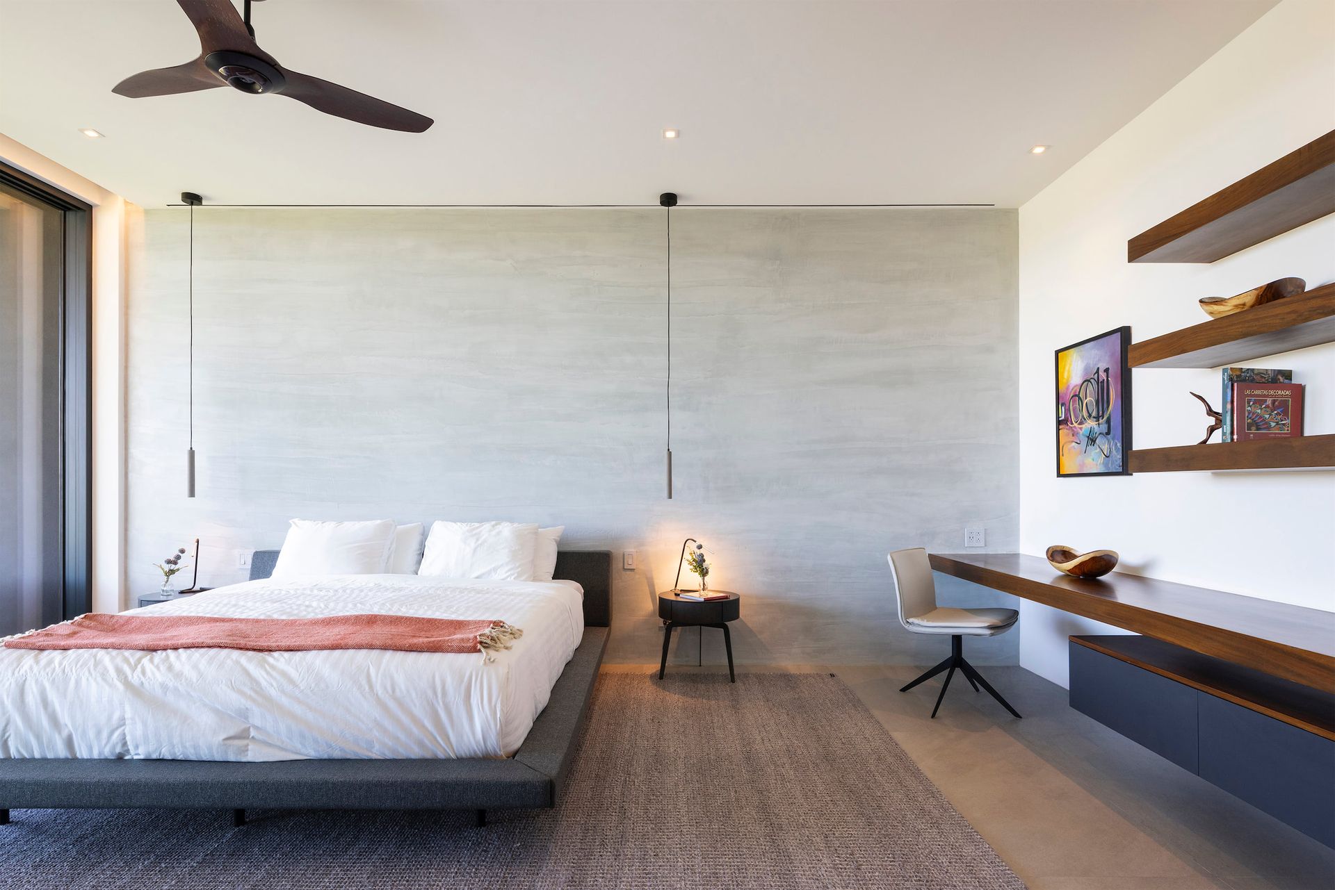 a bedroom with a large bed , desk and ceiling fan .