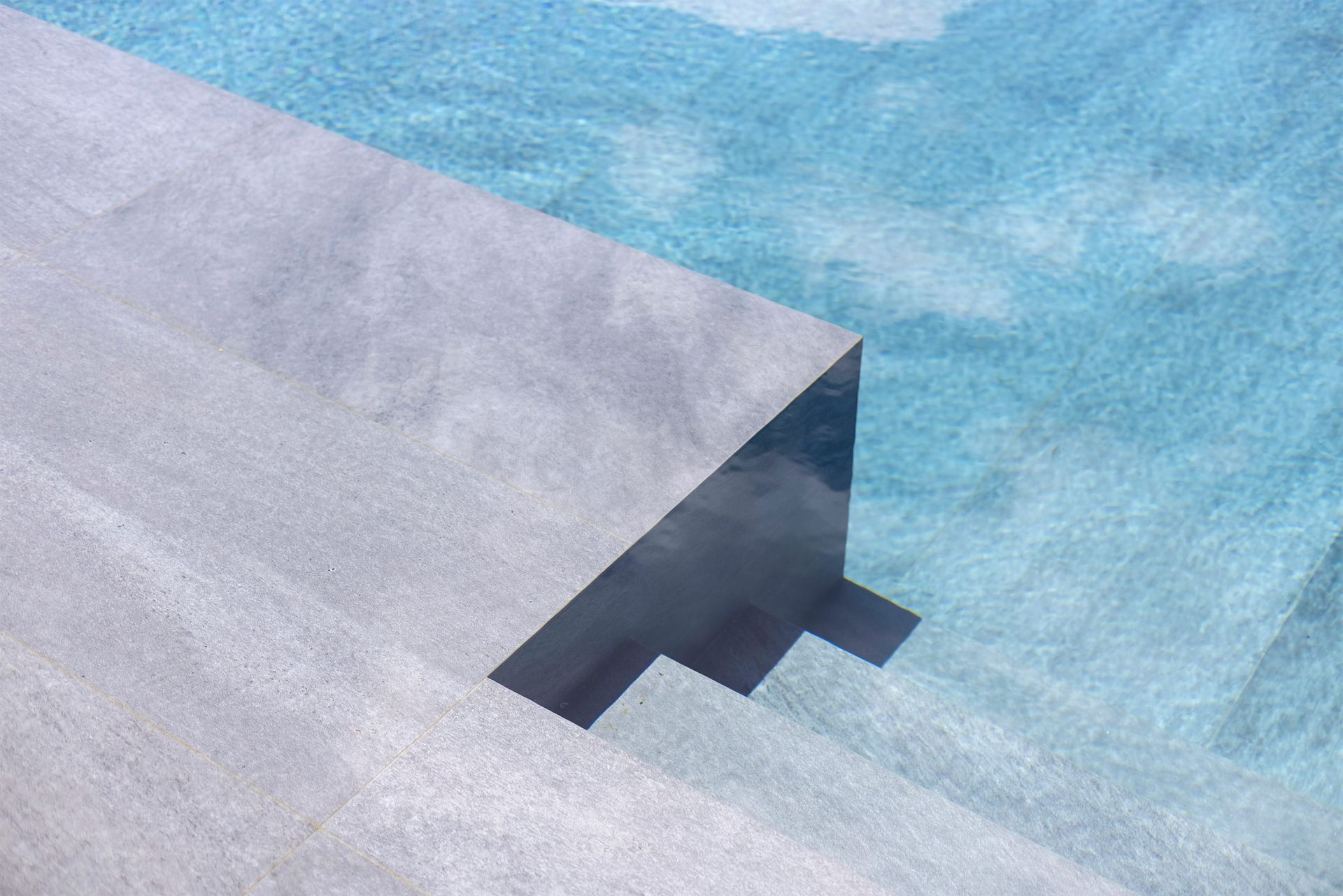 a close up of a swimming pool with stairs leading to it .