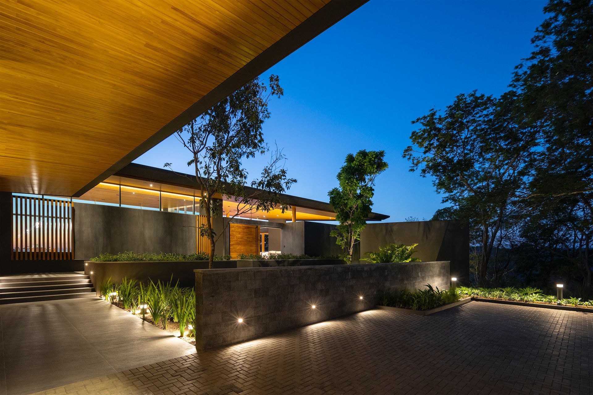 a house with a wooden roof is lit up at night