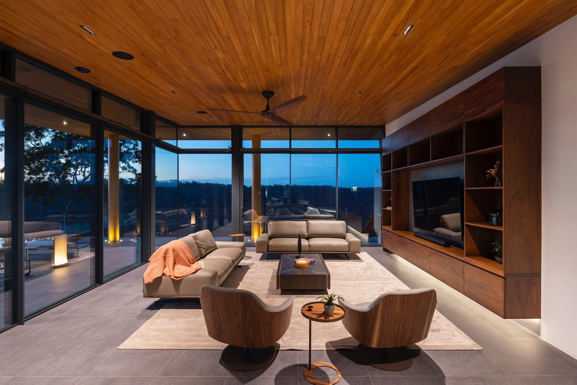 a living room with a couch , chairs and a television .
