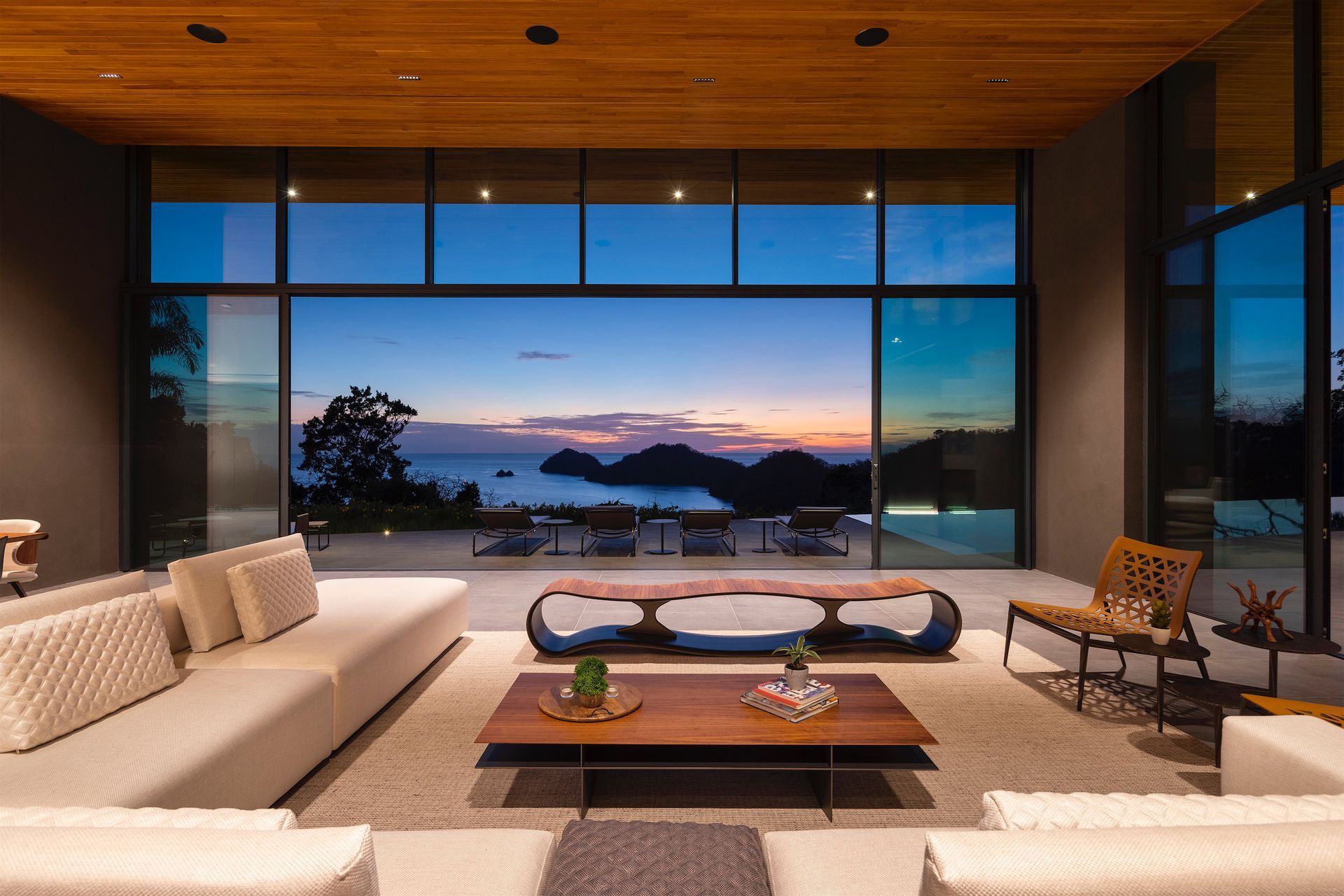 a living room with a lot of windows and a view of the ocean .