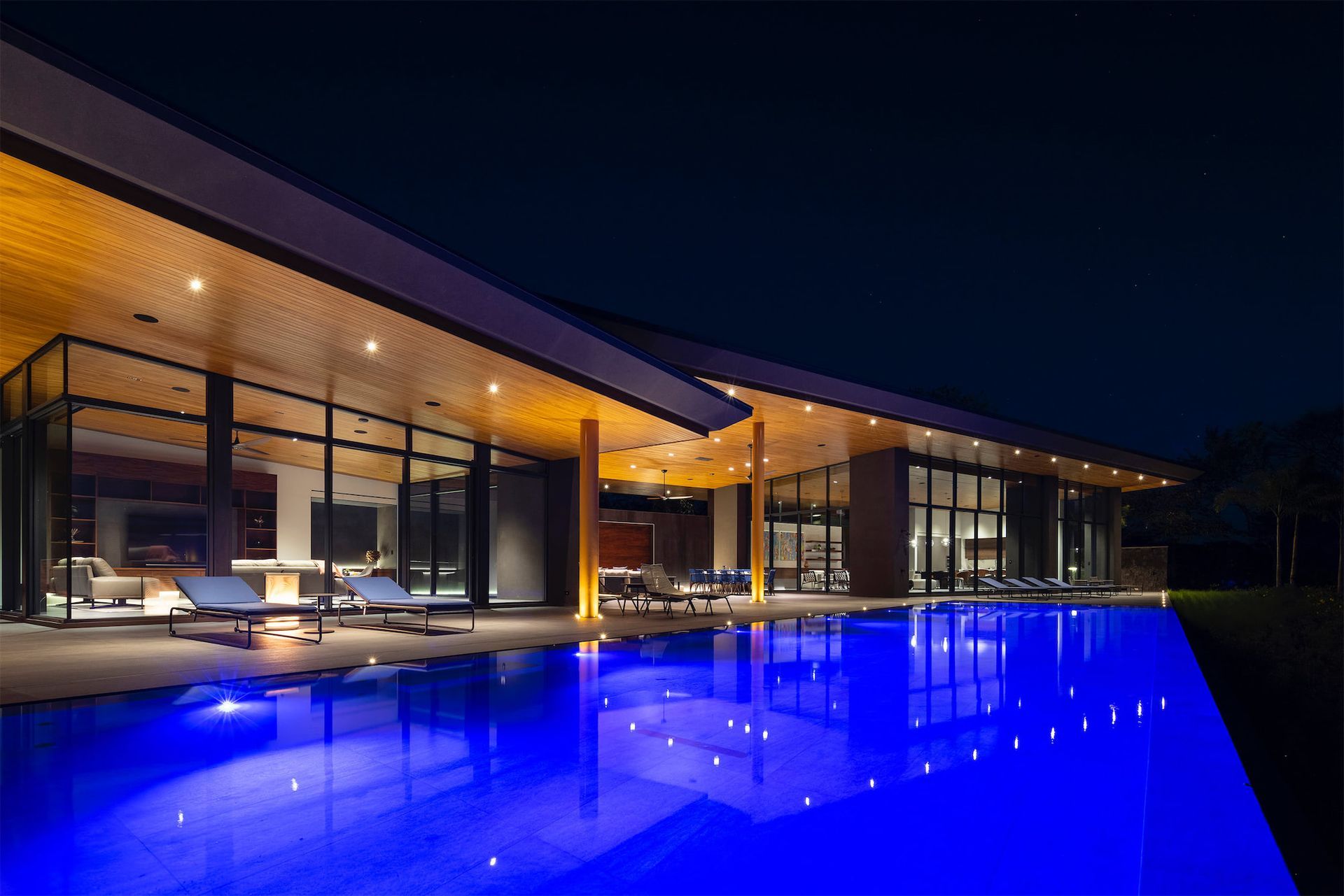 a large house with a swimming pool in front of it at night .