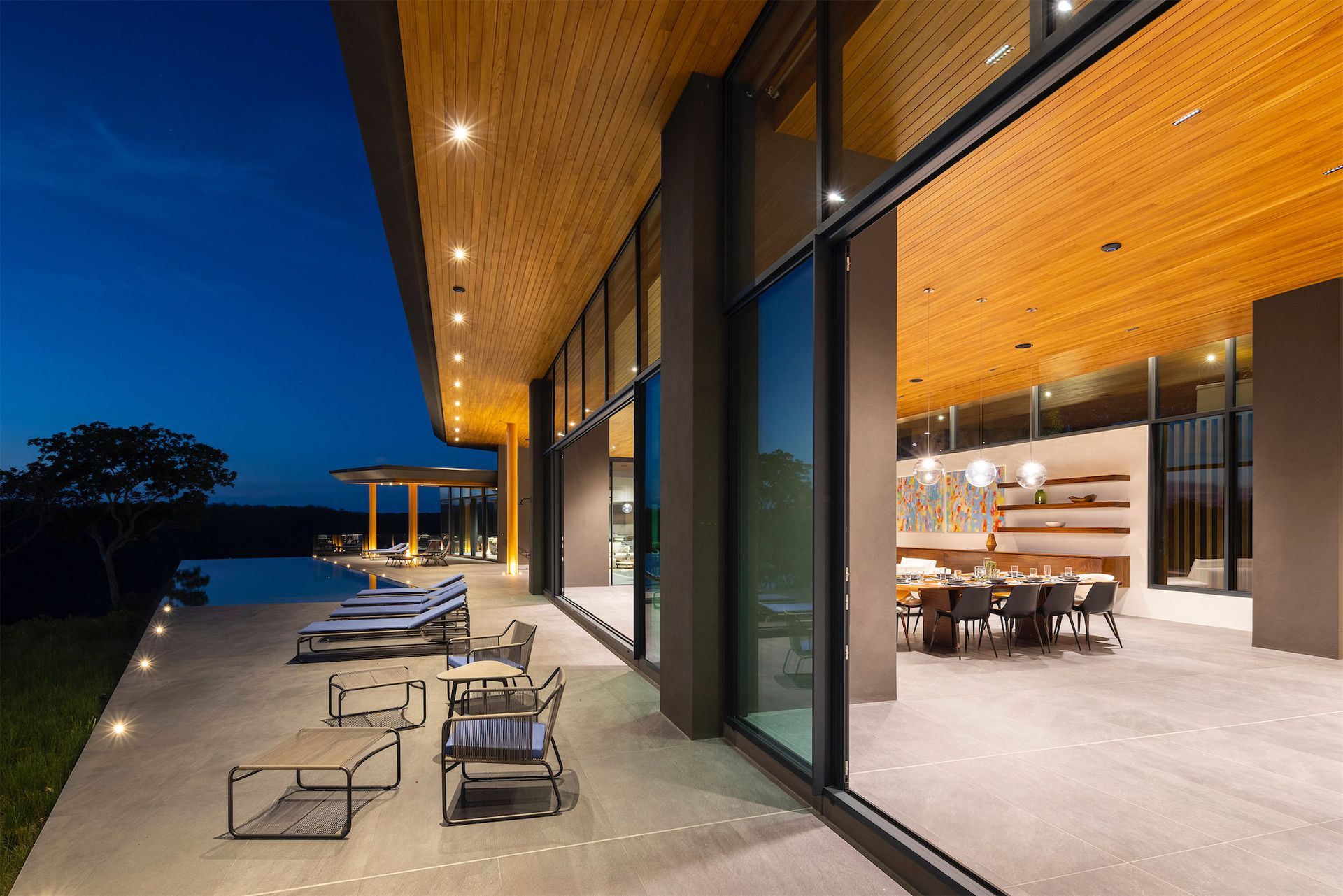 a large house with a lot of windows and a swimming pool at night .