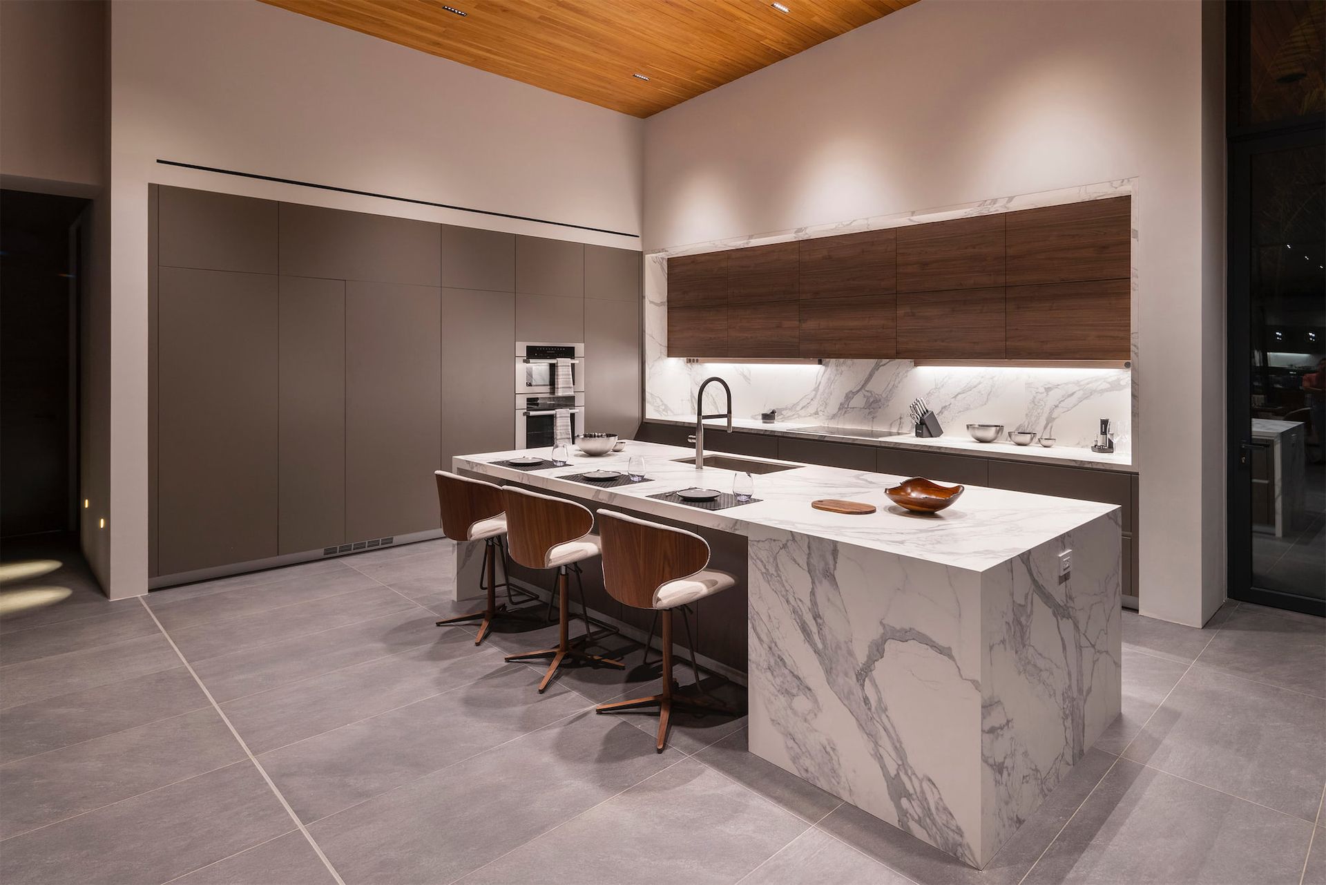 a kitchen with a large island and marble counter tops