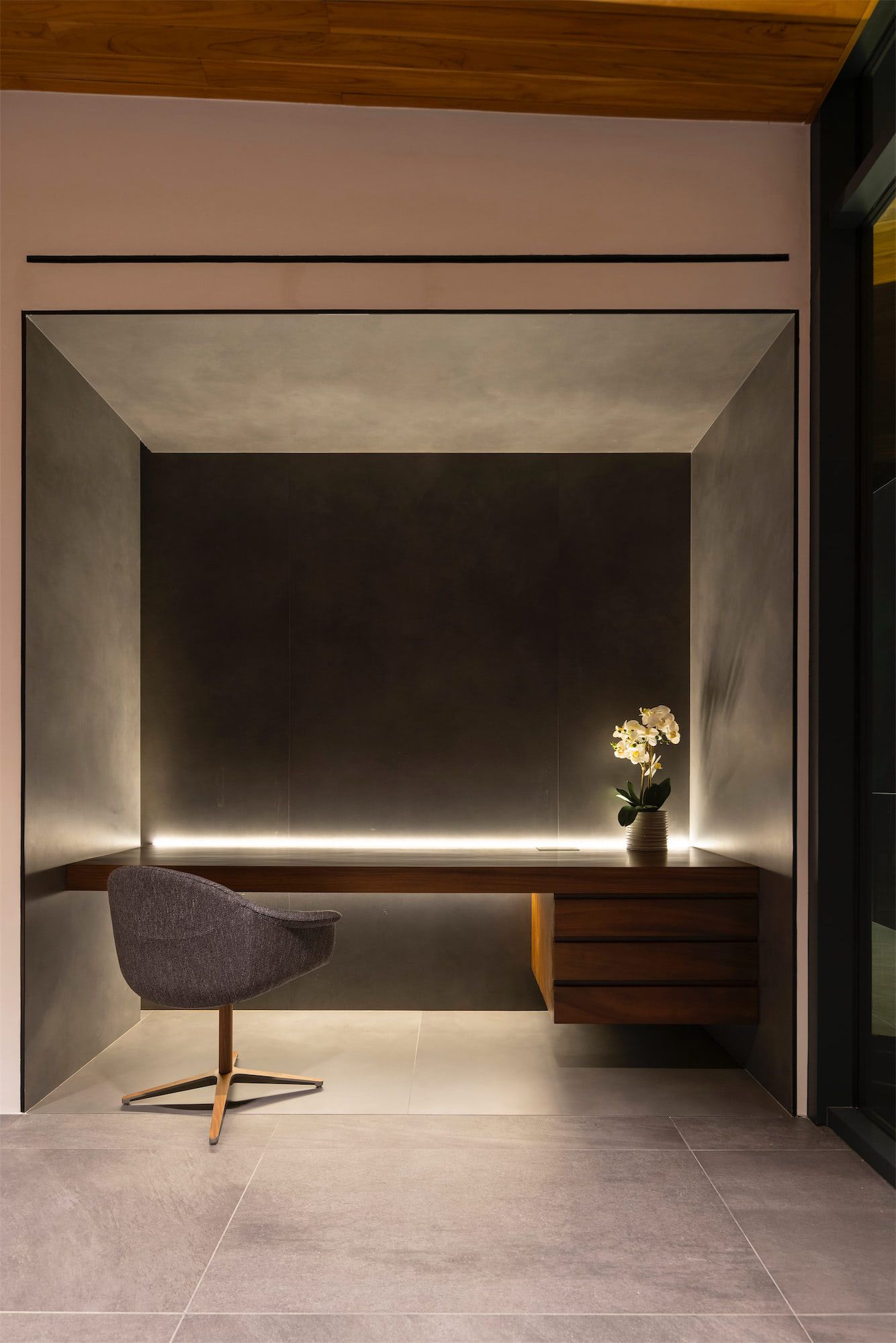 a chair is sitting in a corner of a room next to a desk .