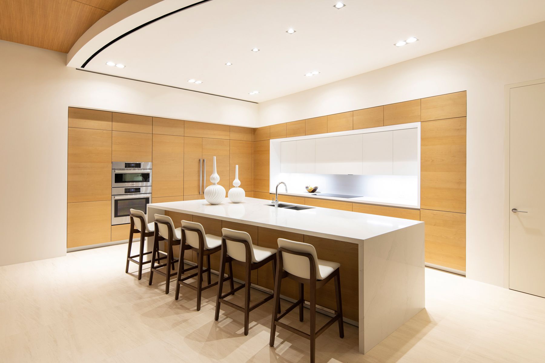 A kitchen with a sink and a dining room in the background. Sarco Luxury home in Costa Rica