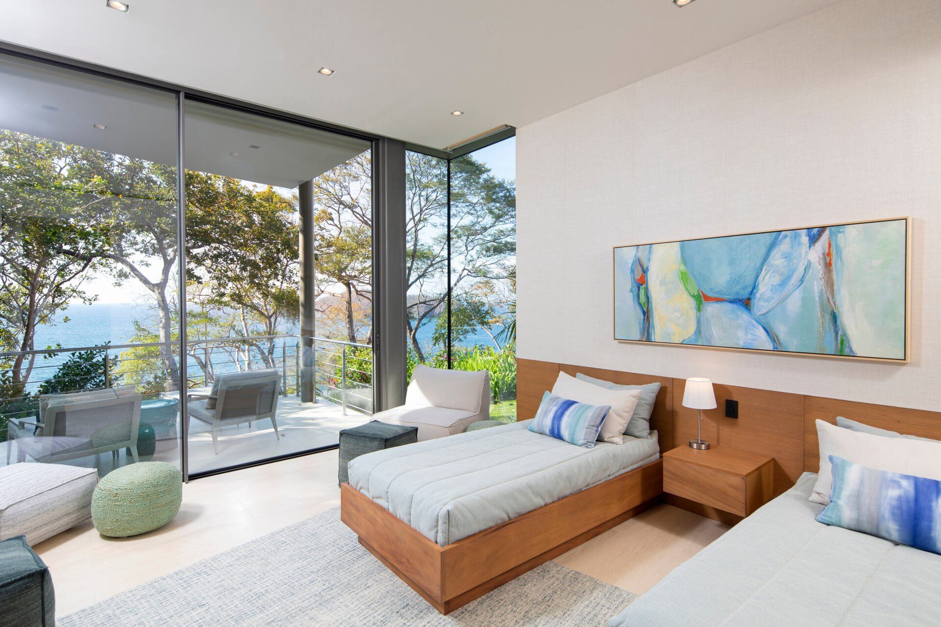 a bedroom with two beds and a large window overlooking the ocean .