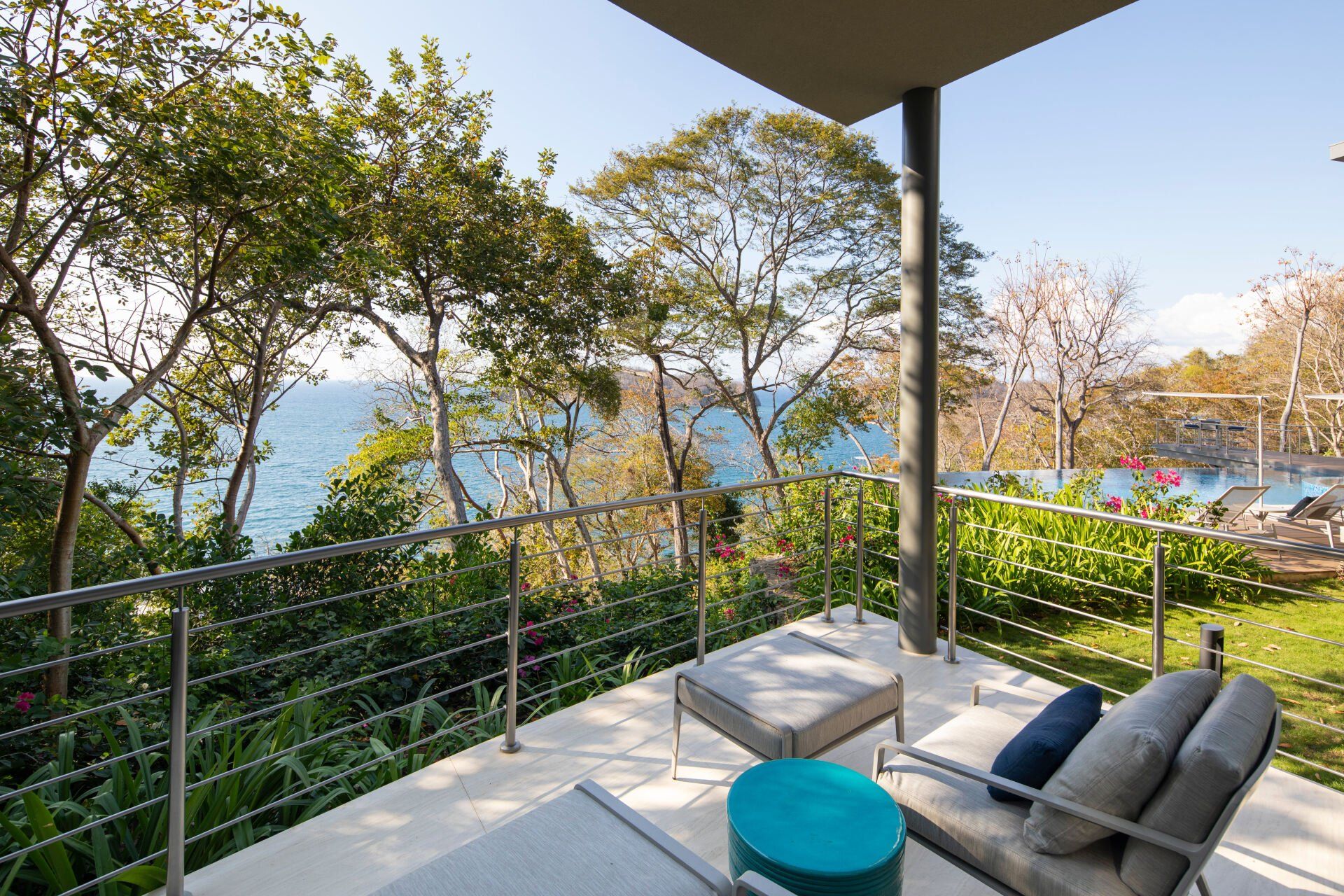 a balcony with a view of the ocean and trees .