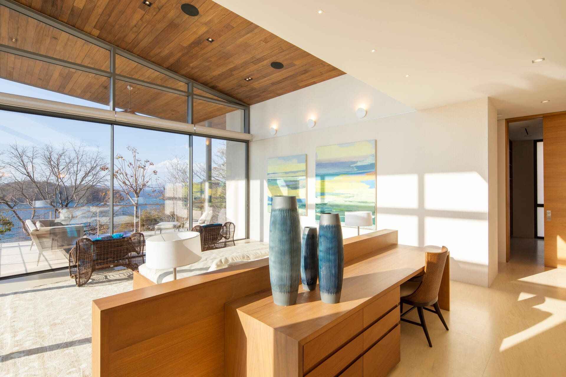 a living room with a desk and two vases on it