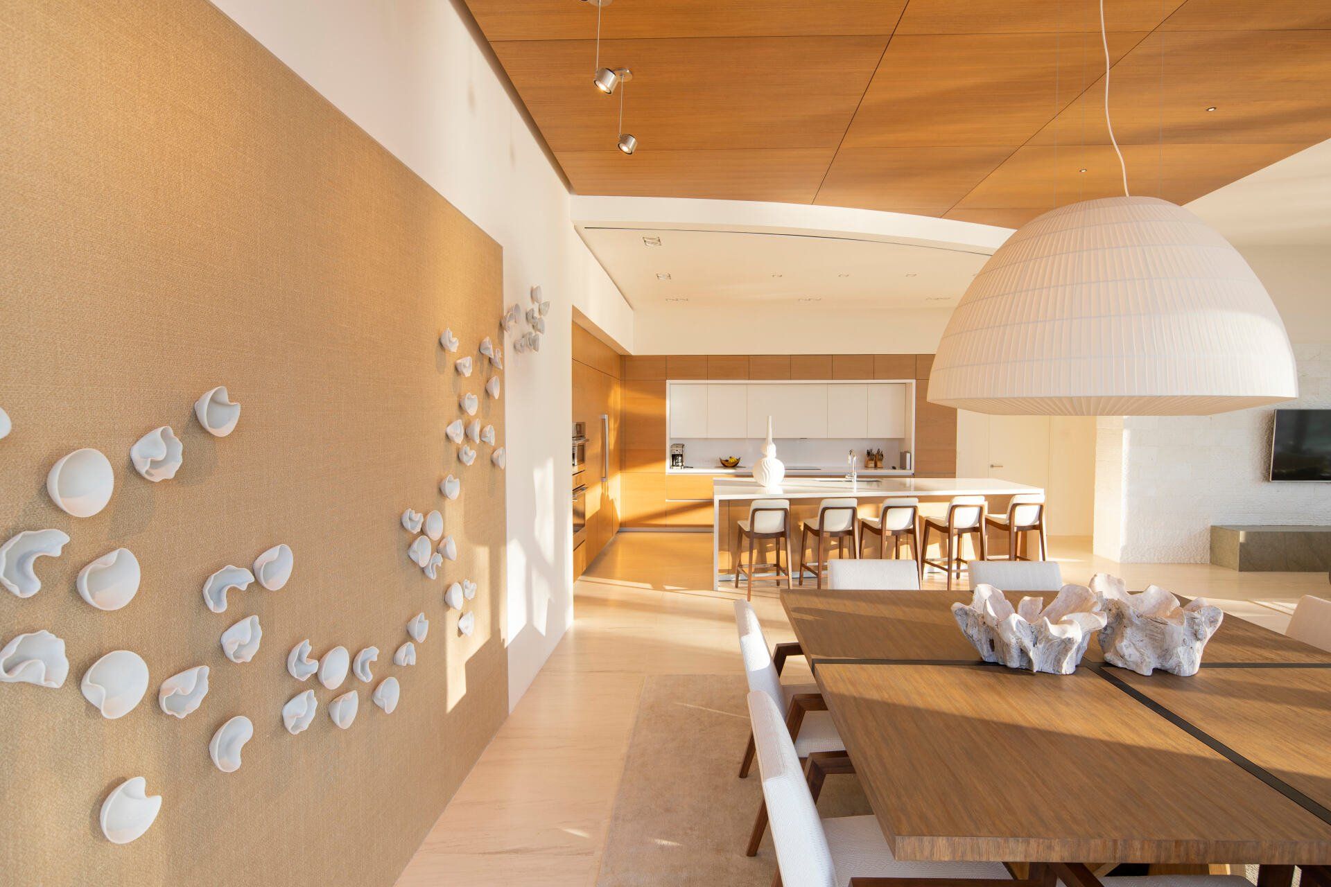 a dining room with a large table and chairs and a cork wall .