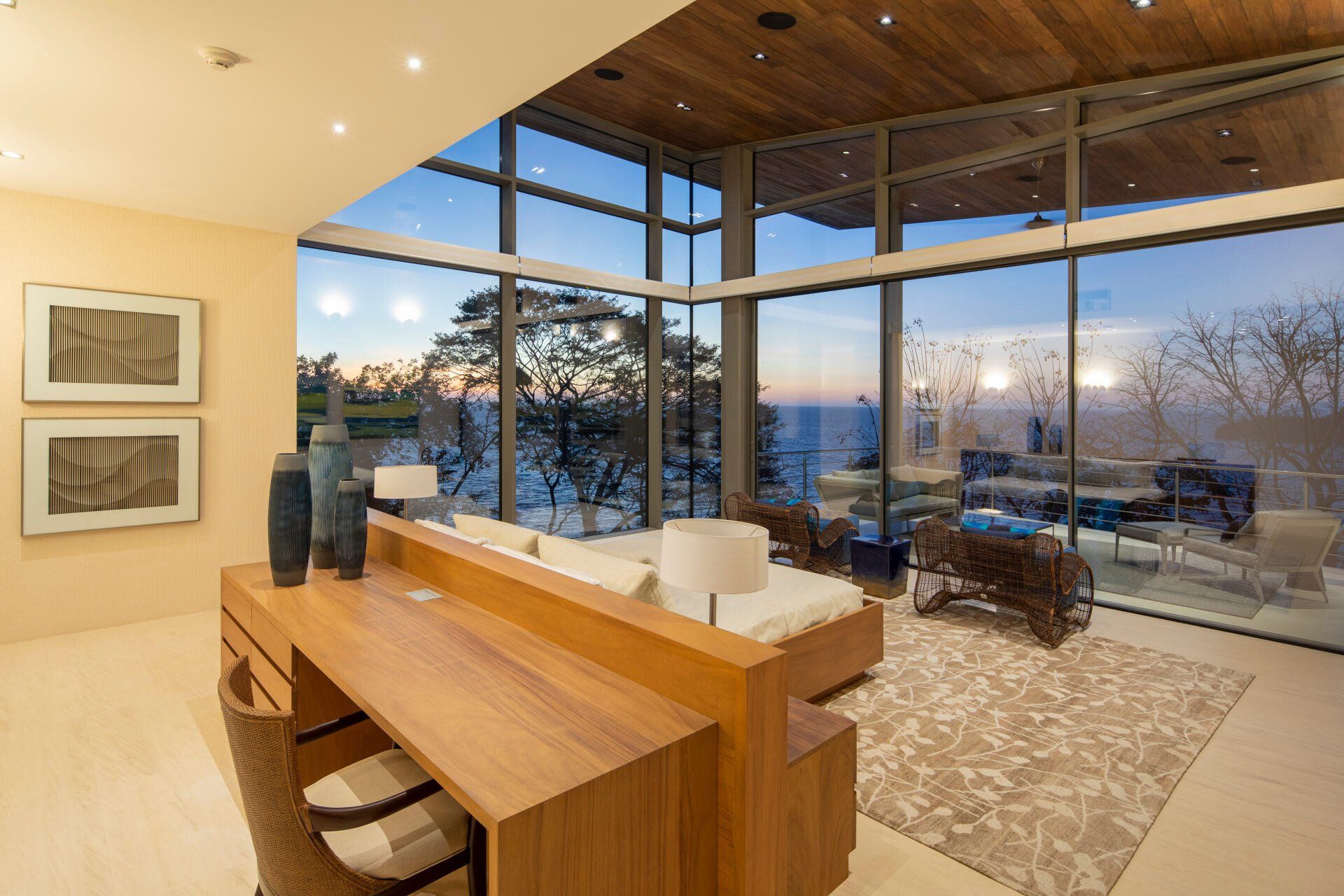 a living room with a lot of windows and a desk
