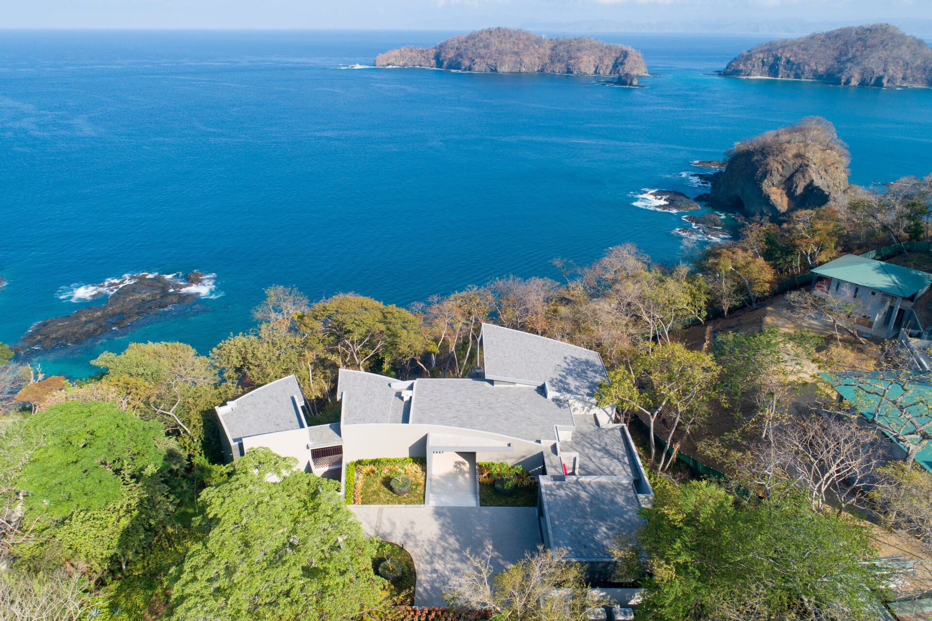 an aerial view of a house on a hill overlooking the ocean .