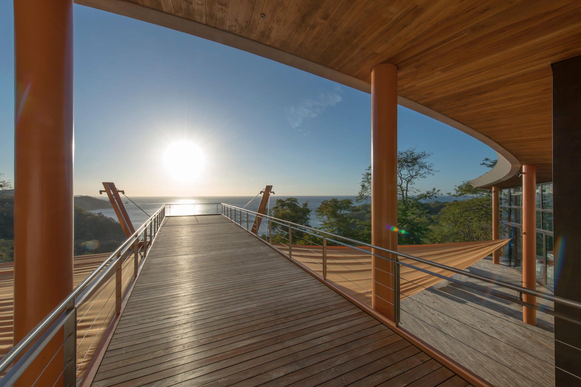 a wooden walkway leading to the ocean with a sunset in the background .