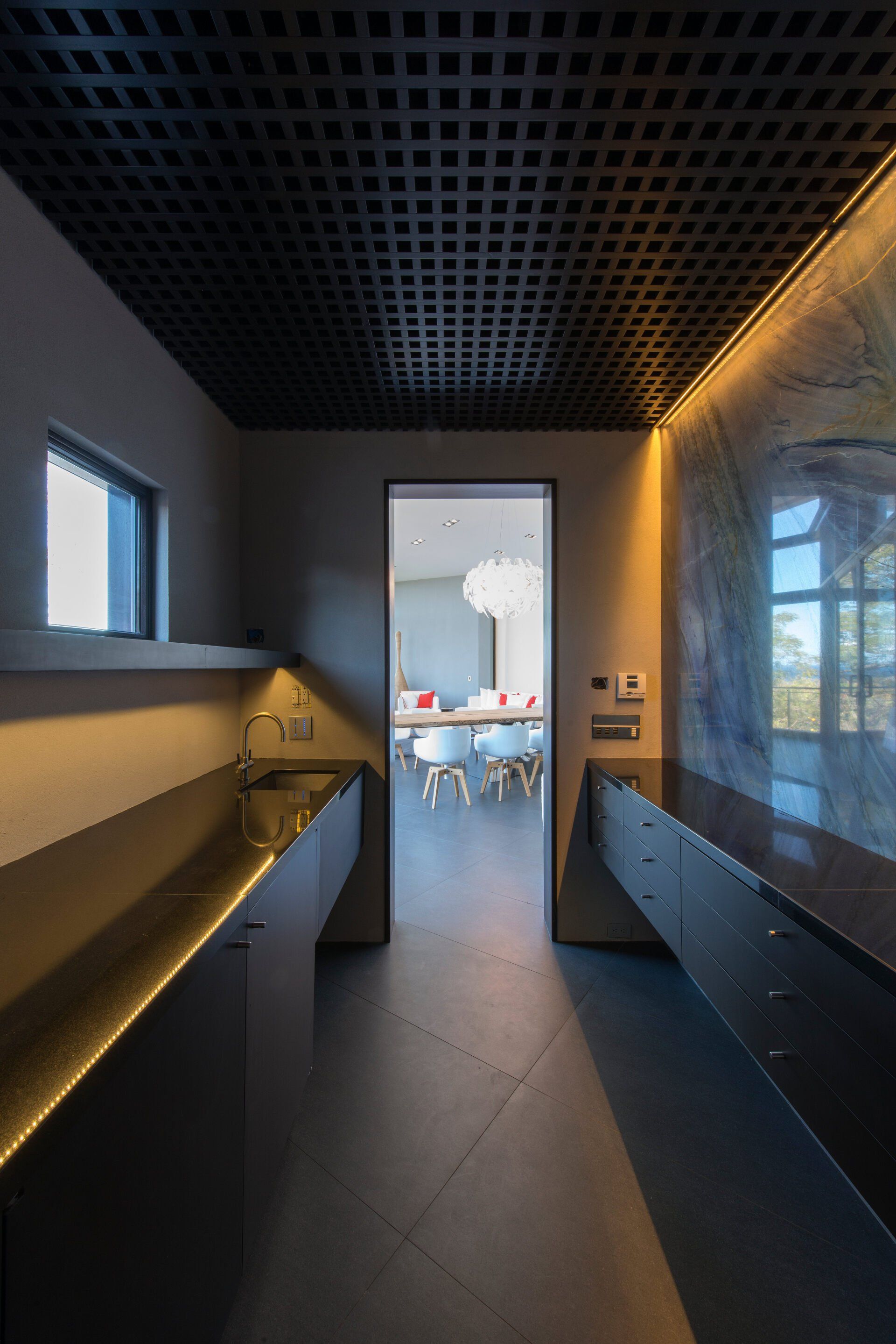 a kitchen with a black ceiling and a dining room in the background .