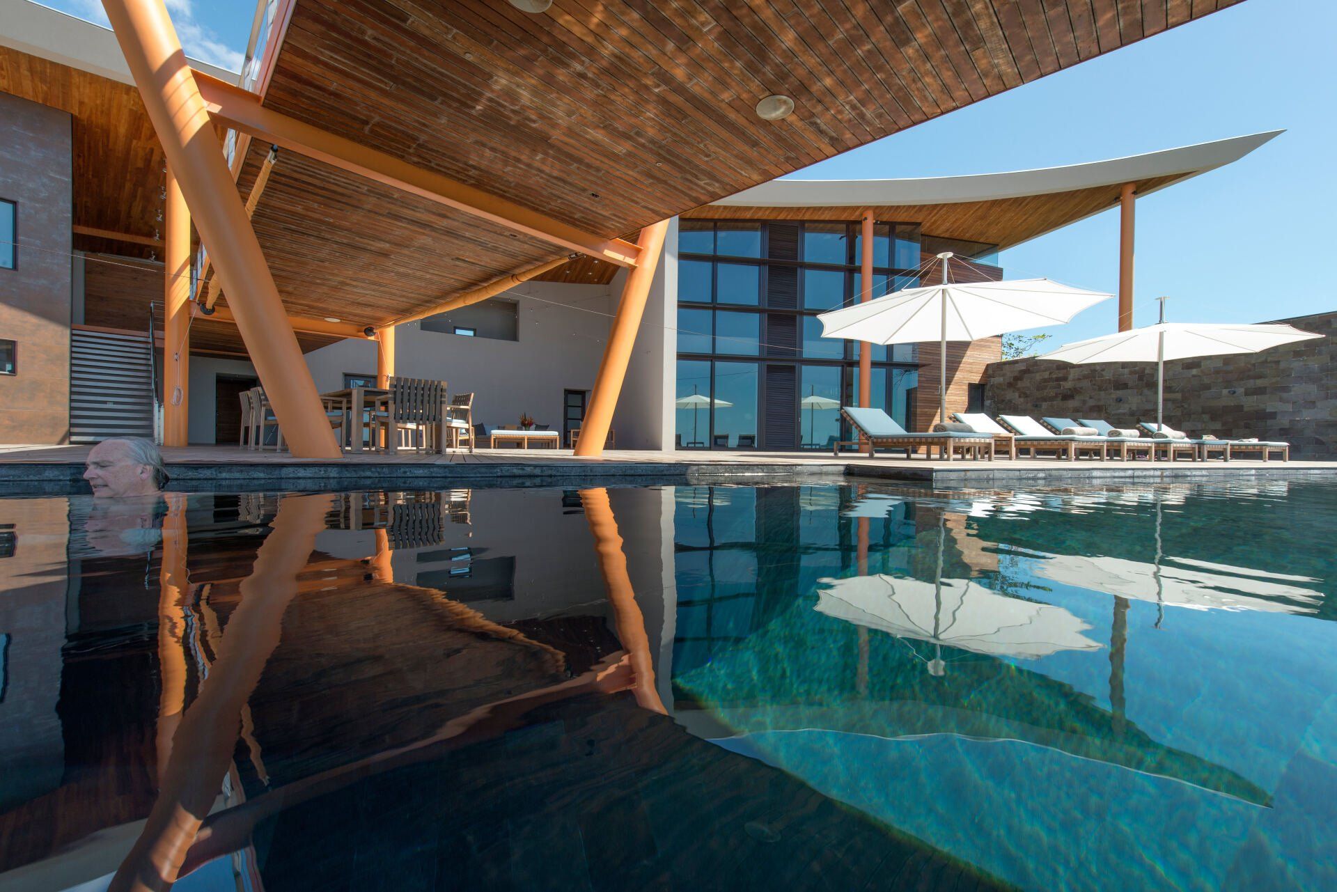 a large swimming pool with chairs and umbrellas around it