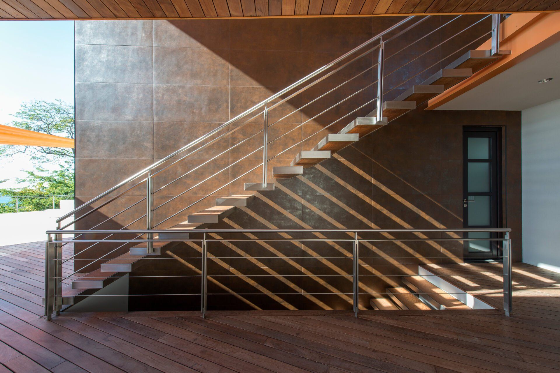 a wooden staircase with a stainless steel railing