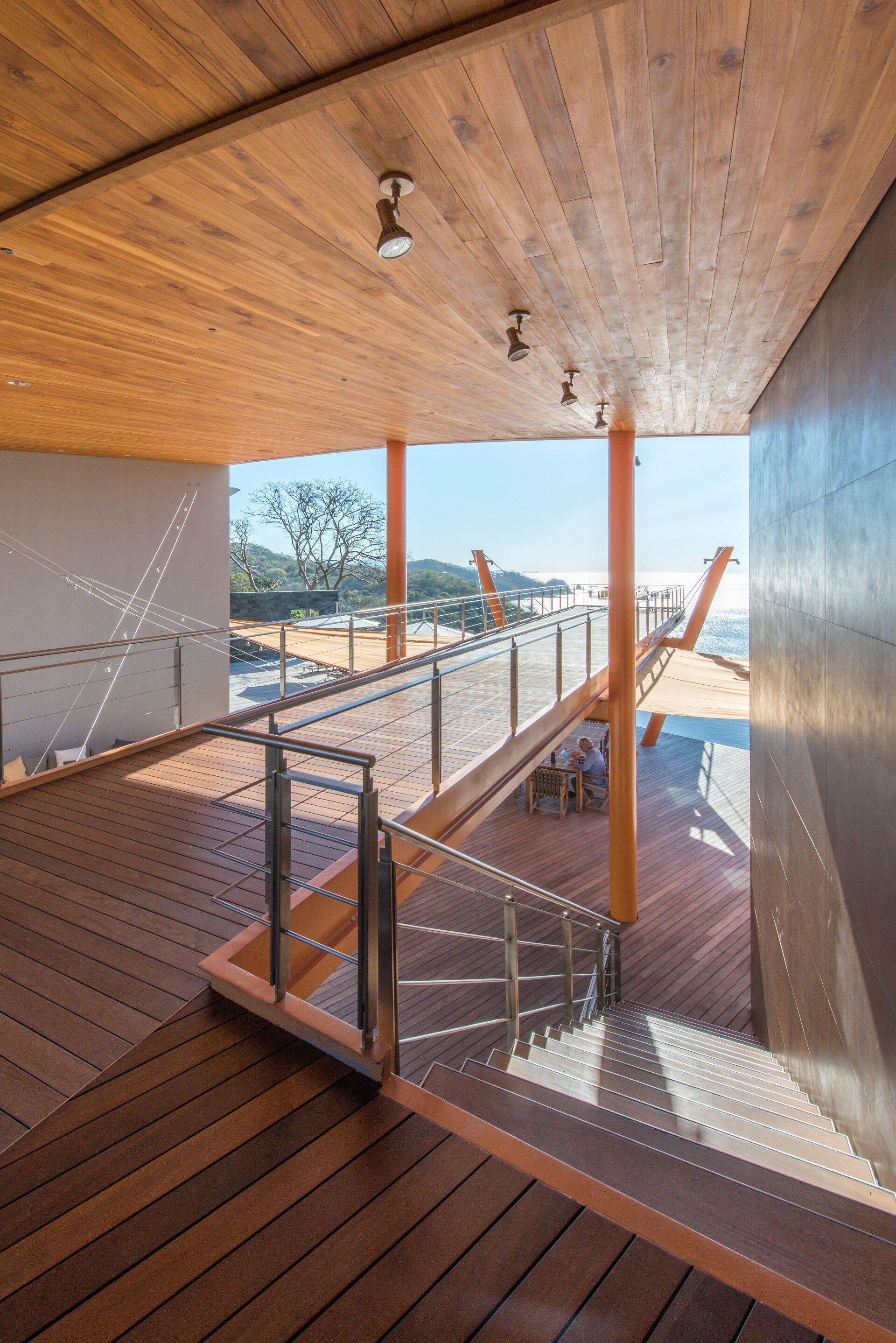 a wooden deck with stairs leading up to it and a view of the ocean .