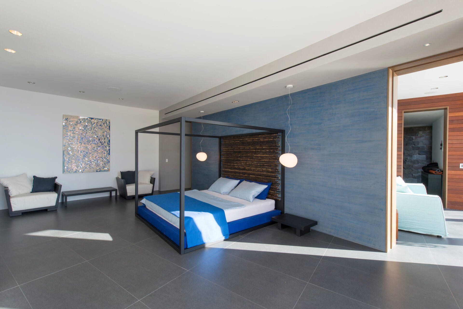 a bedroom with a canopy bed and a blue blanket