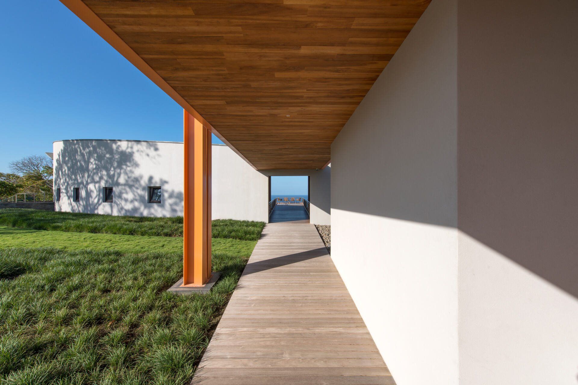 a wooden walkway between two buildings with a wooden ceiling