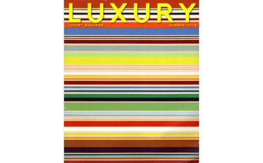 a luxury magazine cover with a colorful striped pattern
