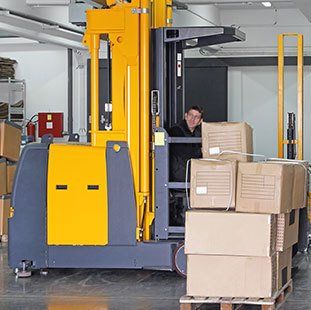 yellow and grey forklift moving boxes