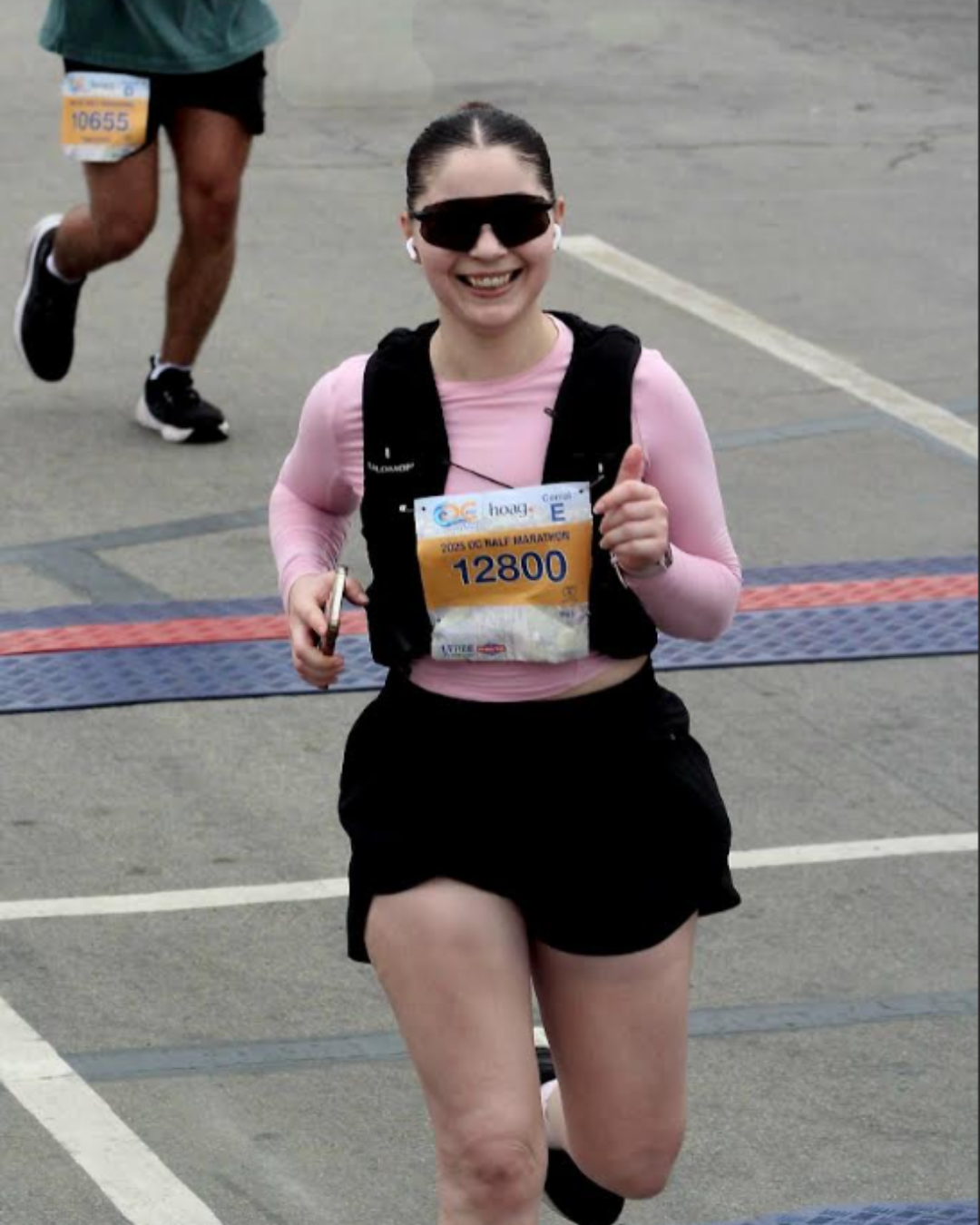 Woman wearing Minnie Mouse ears in front of a castle, posing with hand on hip.