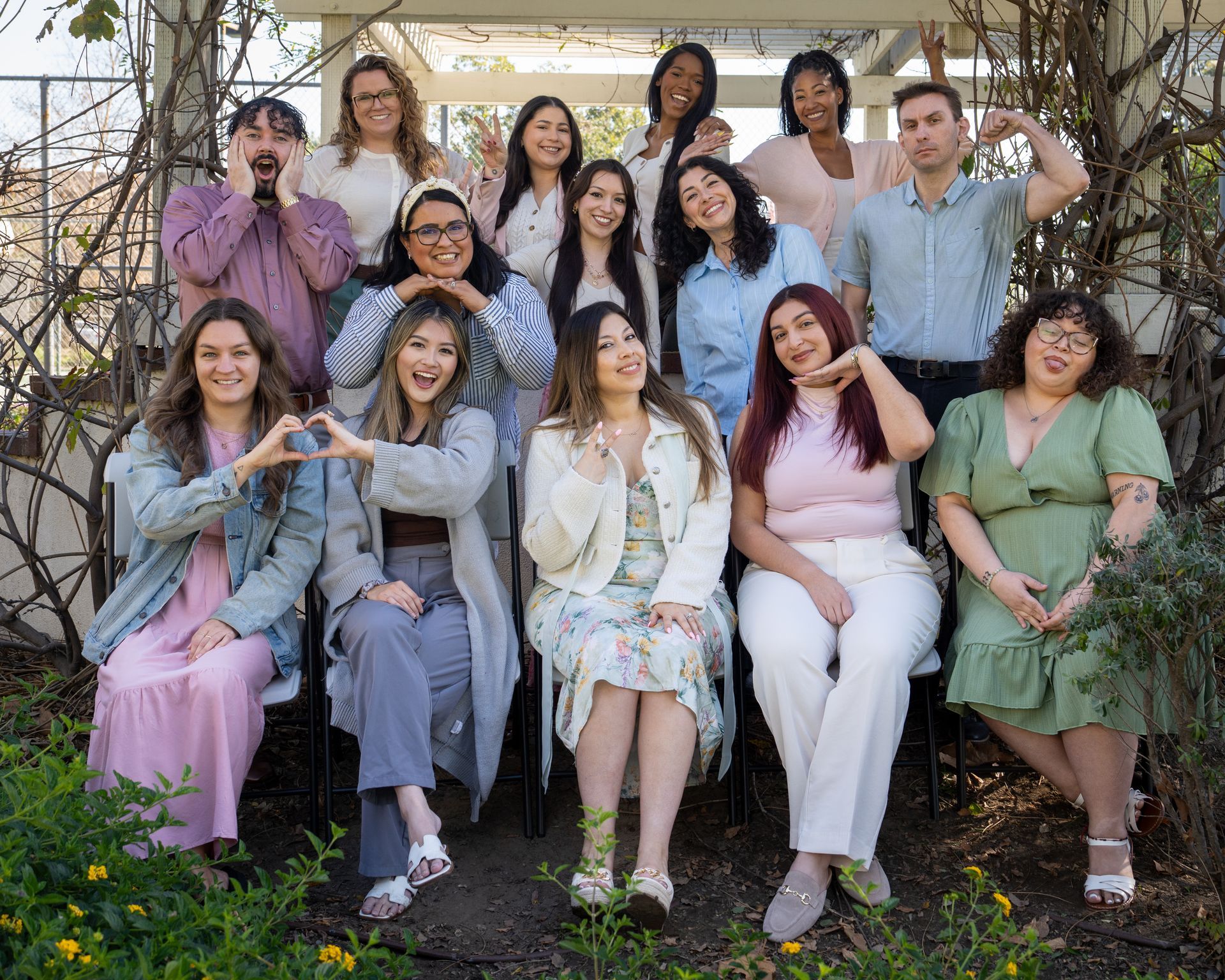 Three women are posing for a picture together in front of a tree.