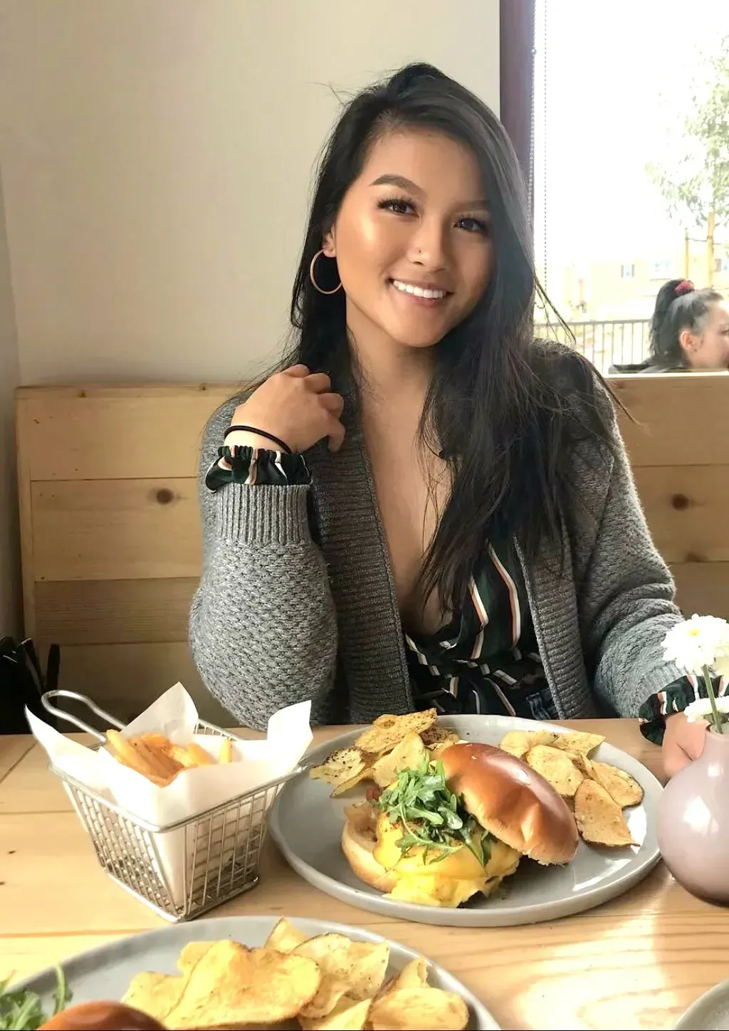 A woman is sitting at a table with a plate of food.