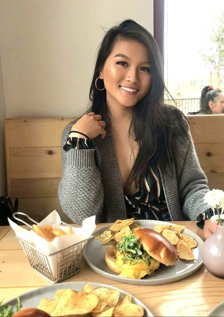 A woman is sitting at a table with a plate of food.