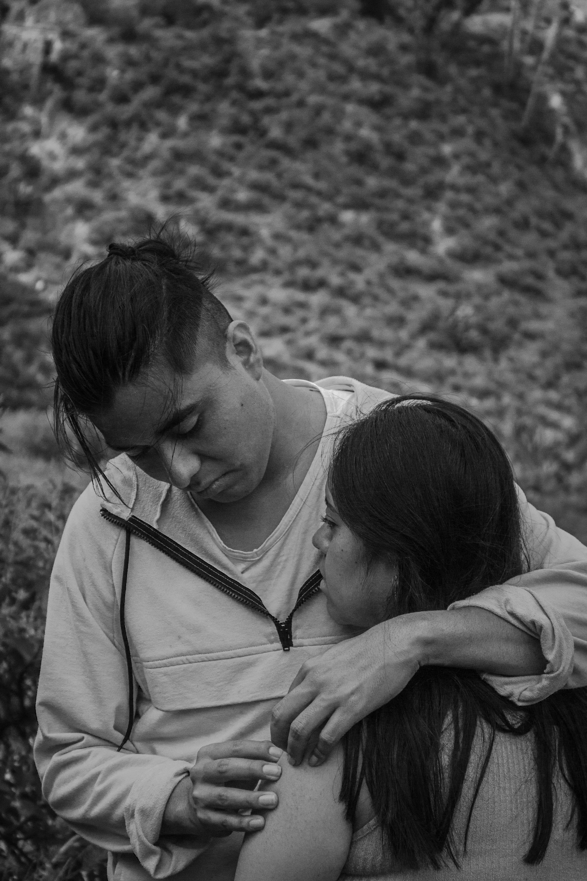 A man is hugging a woman in a black and white photo.