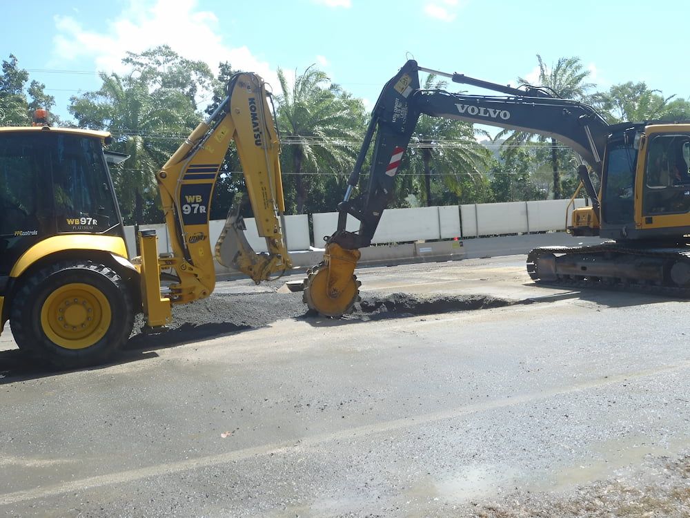 A Volvo Excavator Is Digging A Hole In The Road — S & K Raw Materials & Earthmoving in Atherton, QLD