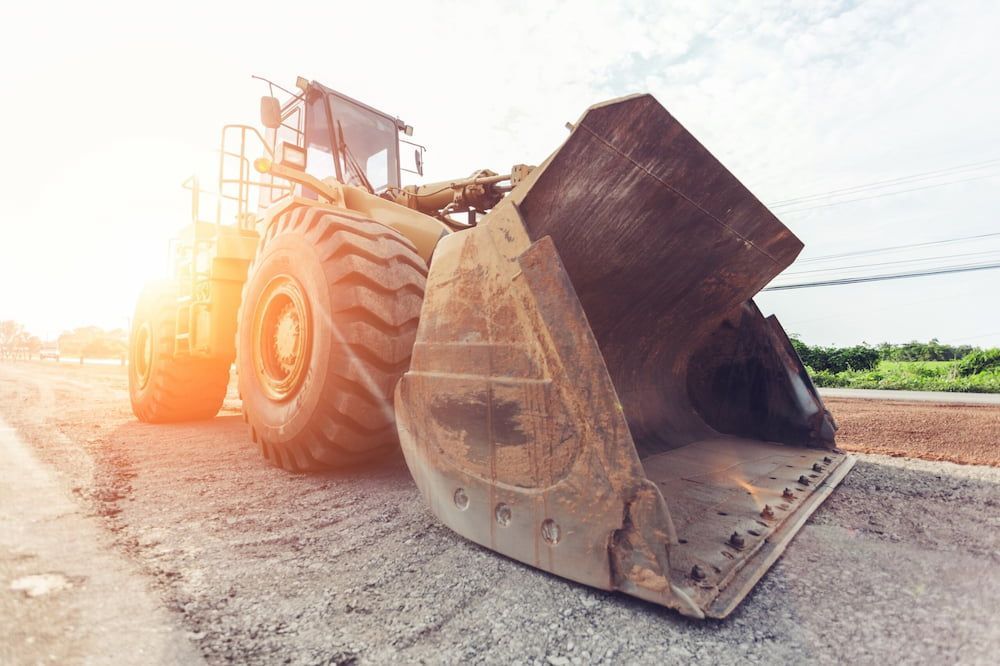 A Bulldozer Is Sitting On The Side Of A Road — S & K Raw Materials & Earthmoving in Atherton, QLD