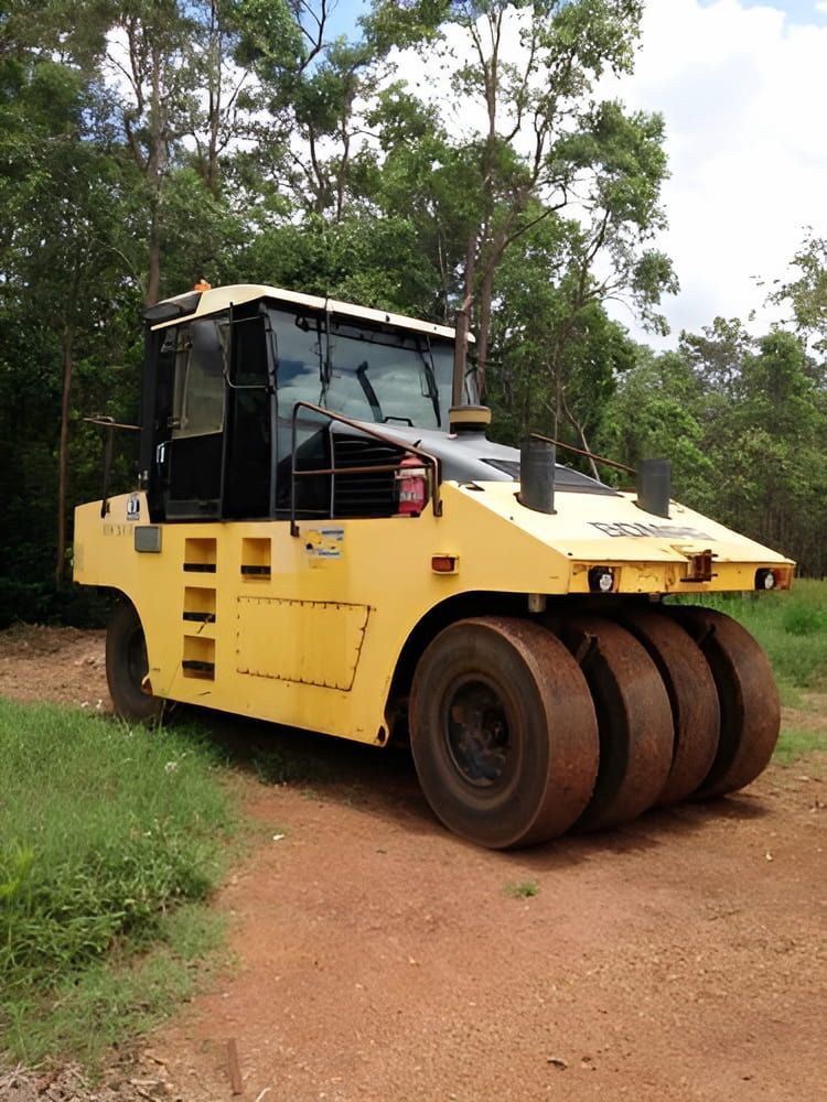 A Yellow Truck With Three Tires Is Parked On A Dirt Road — S & K Raw Materials & Earthmoving in Atherton, QLD