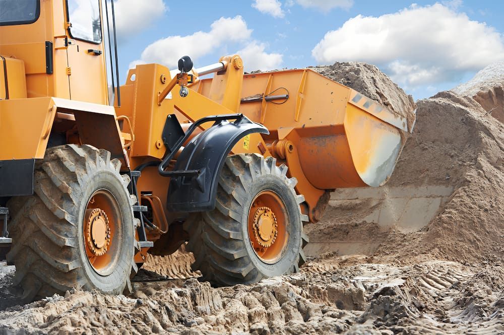 A Yellow Bulldozer Is Moving Dirt On A Construction Site — S & K Raw Materials & Earthmoving in Atherton, QLD