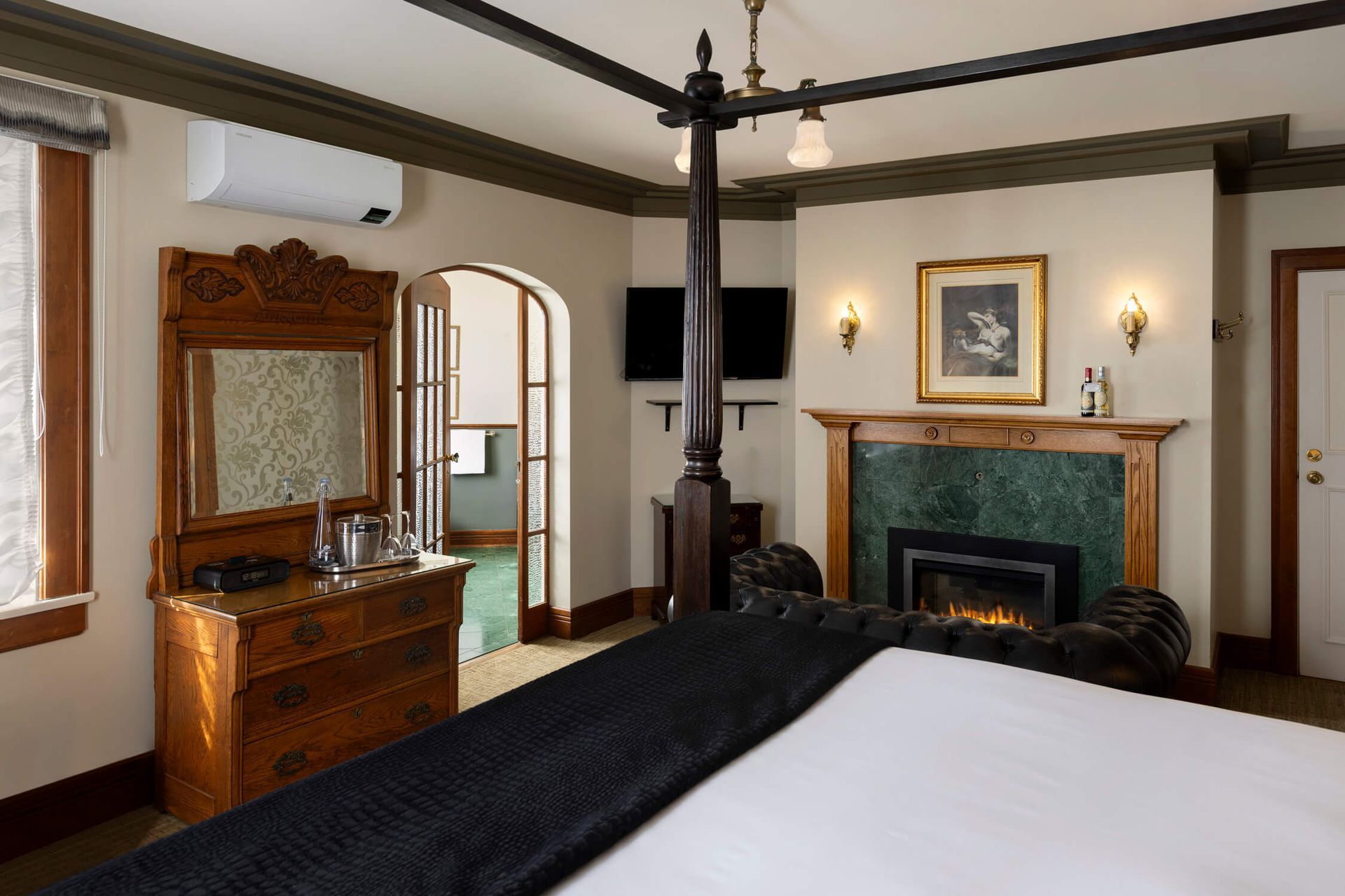 A bedroom with a four poster bed and a fireplace